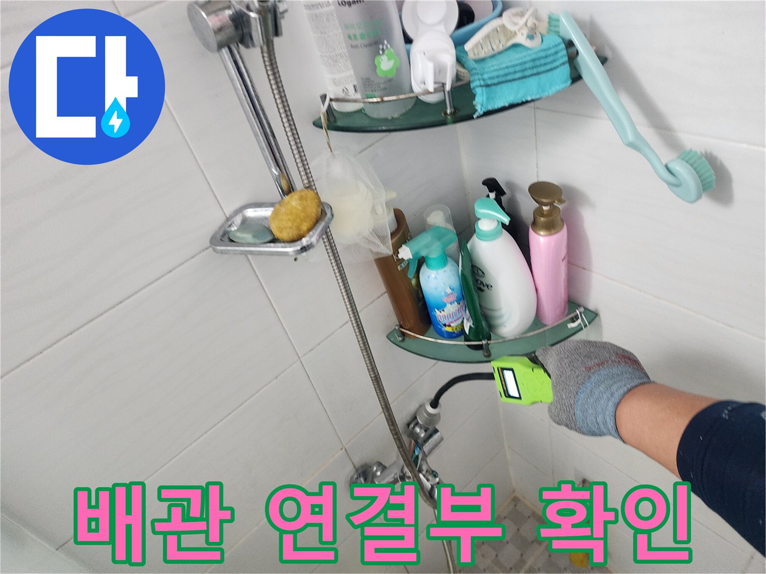 욕실 벽면 배관과 수전 연결 부위의 누수 여부를 점검하는 장면