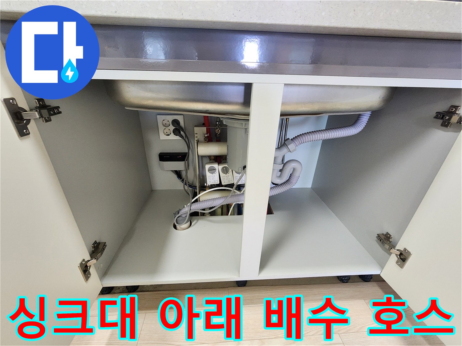 싱크대 하단부의 굵은 배수 호스와 하수관 연결 모습