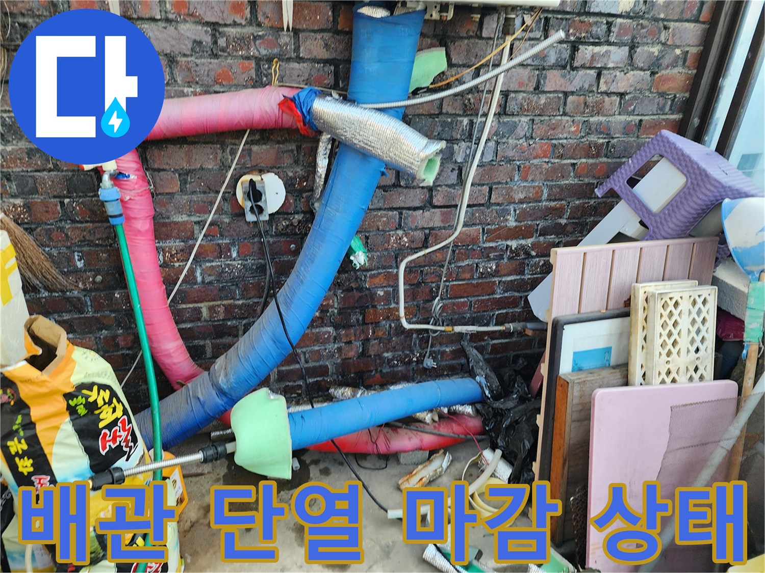 분홍색 및 파란색 튜브형 배관과 벽돌 벽면의 연결 부위