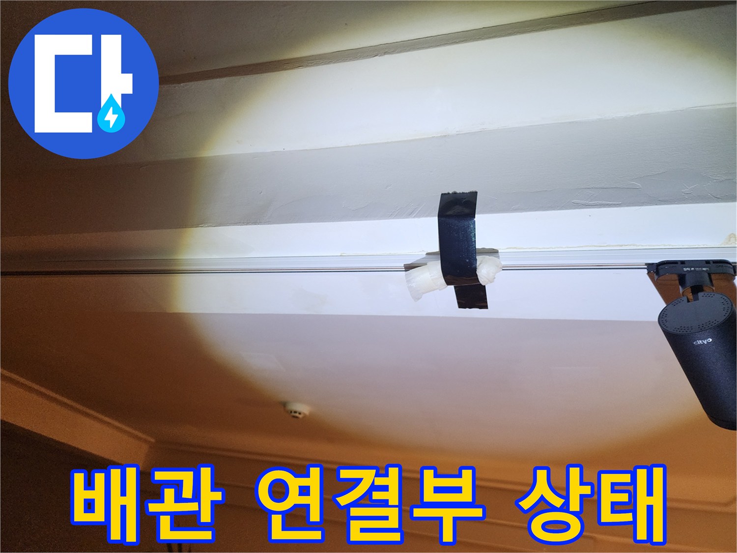 천장 구조물 사이 배관에 감겨 있는 검은색 테이프 근접 촬영