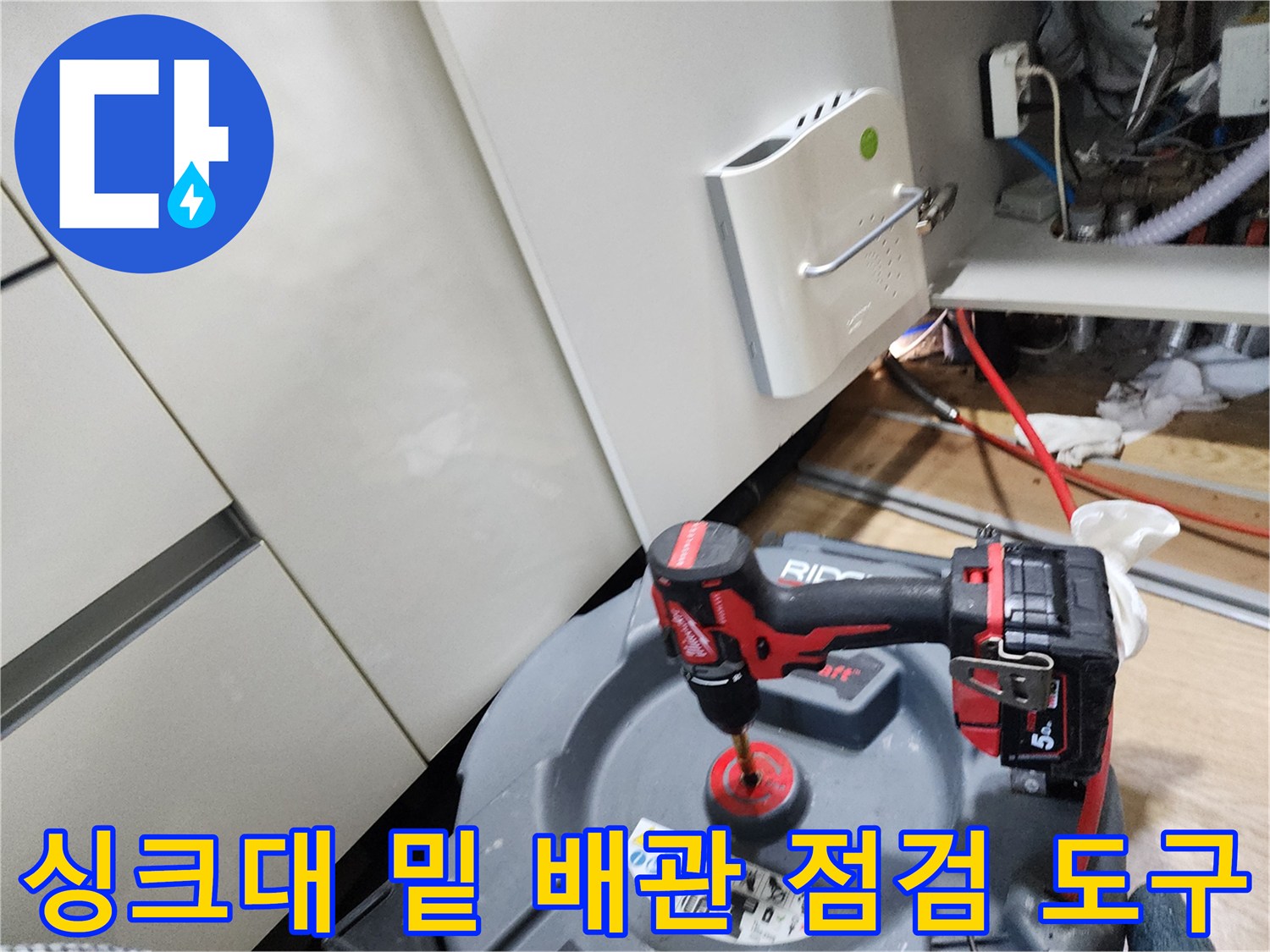 배관 내부를 살피기 위한-내시경 장비와 전동 공구가 놓인 싱크대 하부