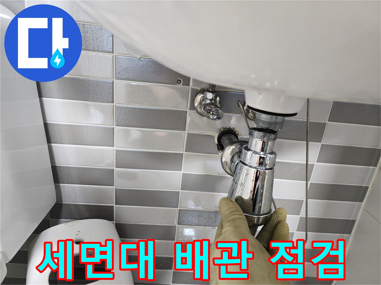 세면대 하부 트랩과 연결 부위를 점검하는 모습입니다.