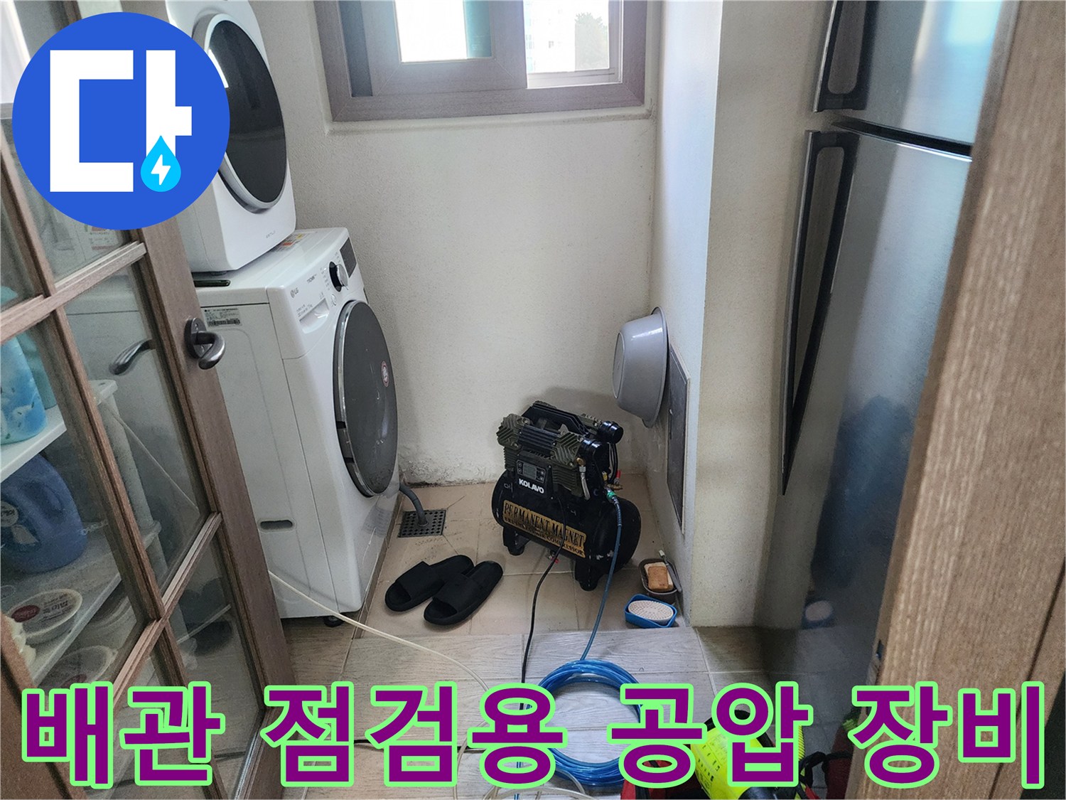 세탁기 옆 공간에 배치된 검정색 에어 컴프레셔