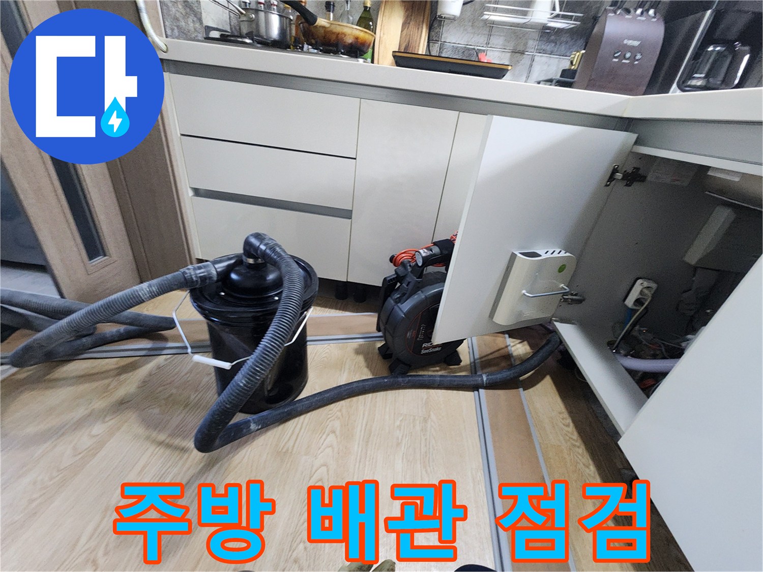 싱크대 하부 공간의 누수를 확인하기 위해 설치된 흡입 장비와 호스입니다.