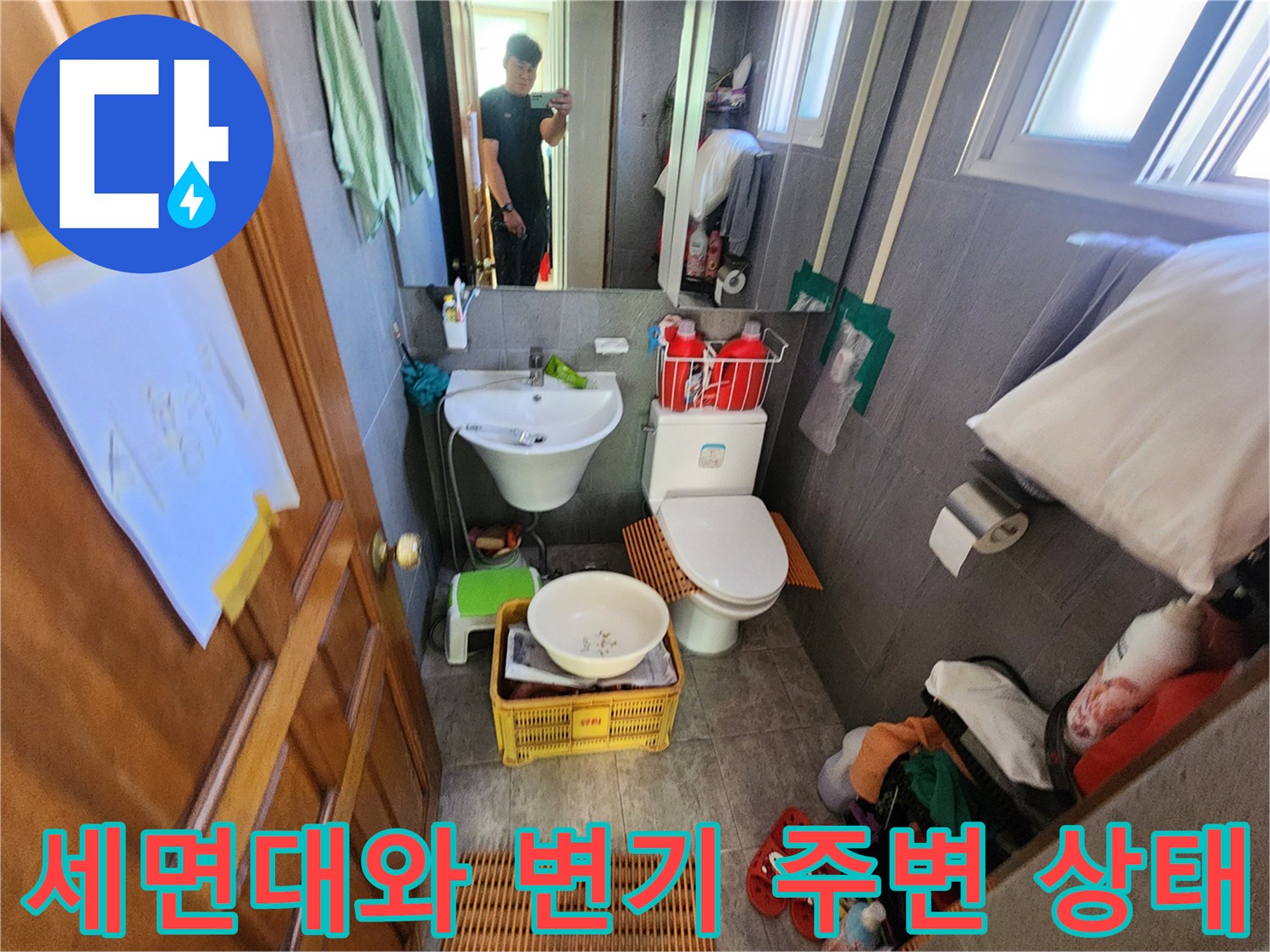 욕실 내부의 세면대 하부와 변기 주변을 촬영한 사진입니다.