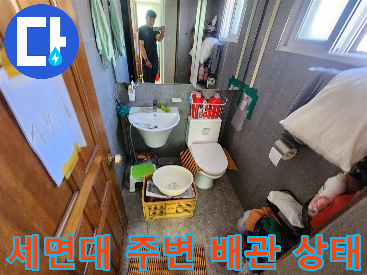 화장실 내부의 세면대 하부 배수 시스템 점검 중