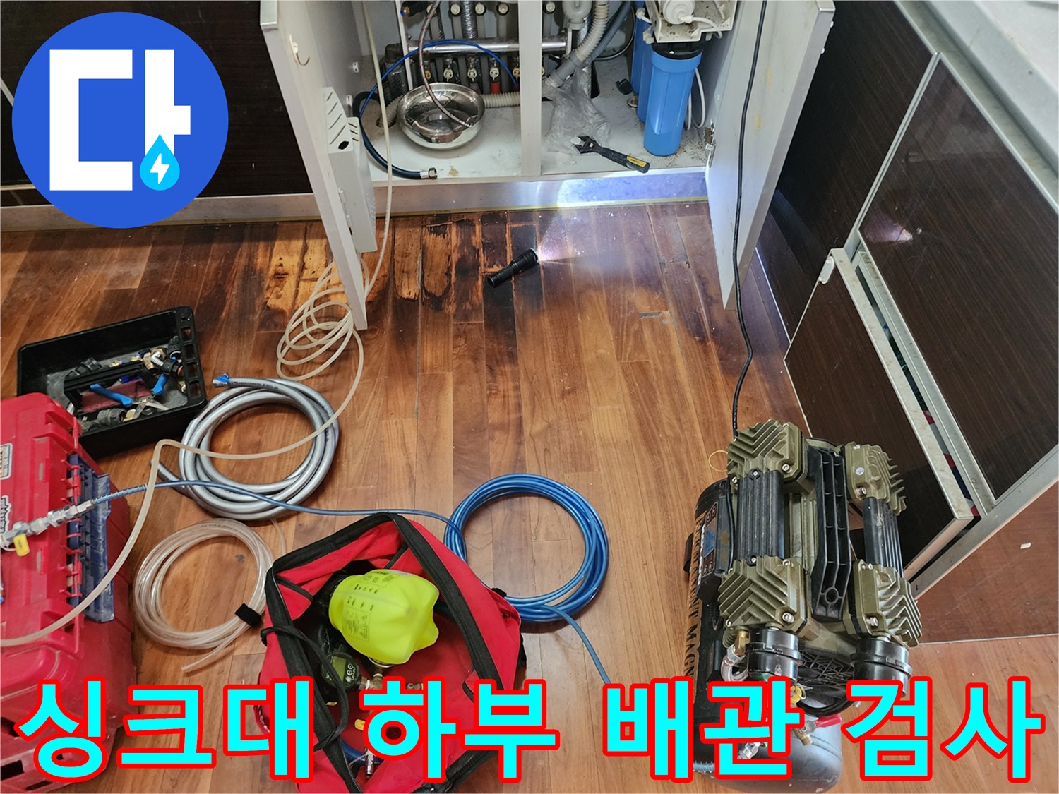 에어 호스와 컴프레셔를 이용해 싱크대 하단 배관의 누수를 찾는 현장
