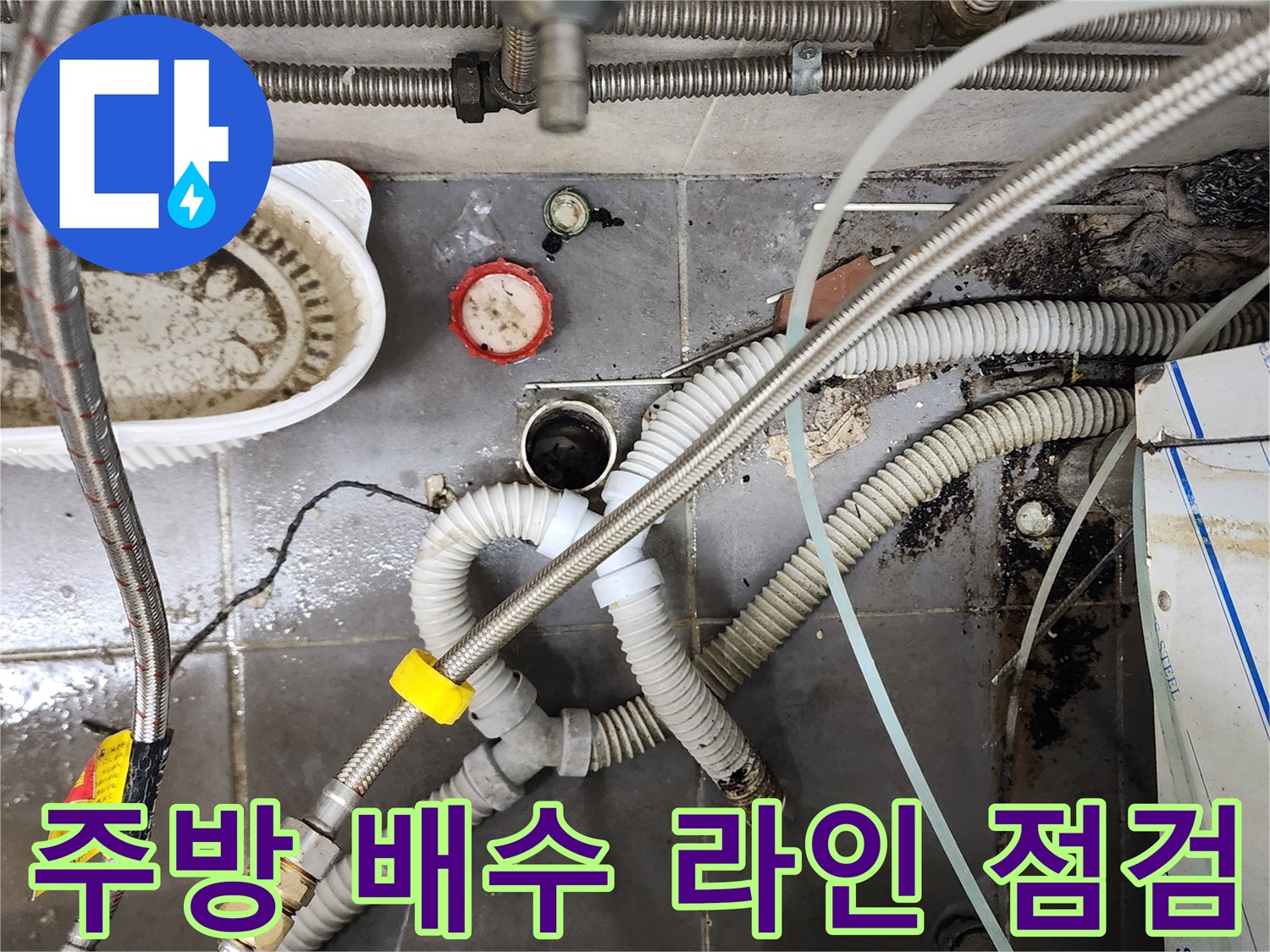 복잡하게 얽힌 은색 자바라 호스와 바닥 배수구 연결 상태