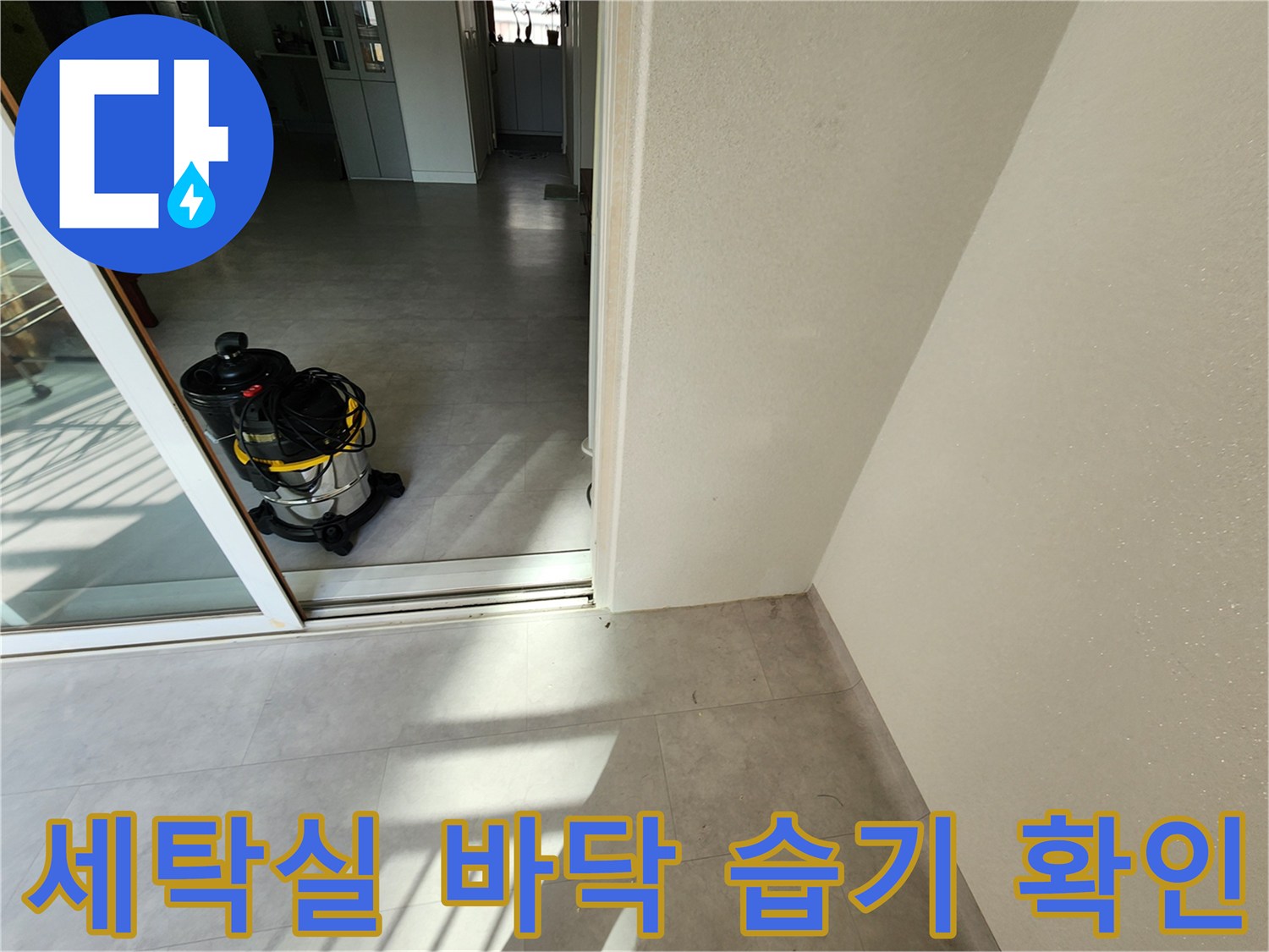 베란다 내부 타일 바닥과 작업용 청소기가 놓여 있는 모습