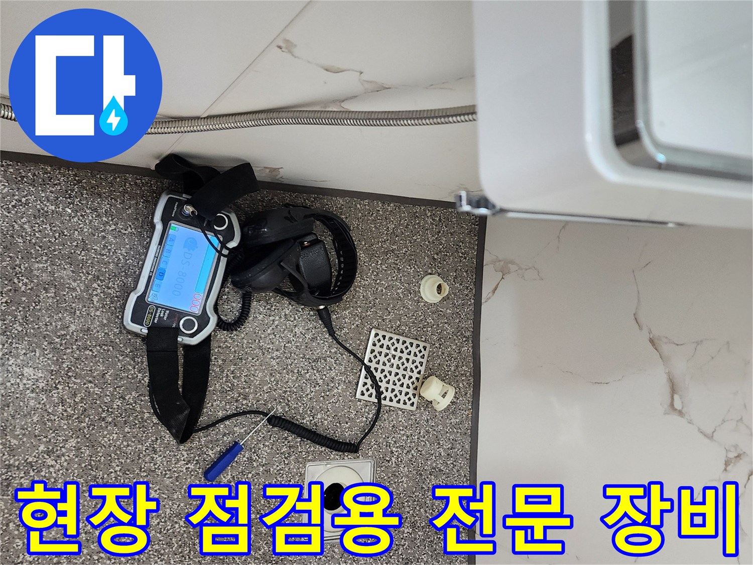바닥 타일 위에 놓인 누수 탐지용 가스 및 청음 장비 세트