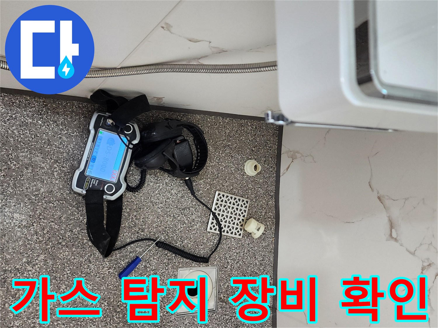욕실 바닥에 놓인 가스 탐지기와 전문 점검 장비