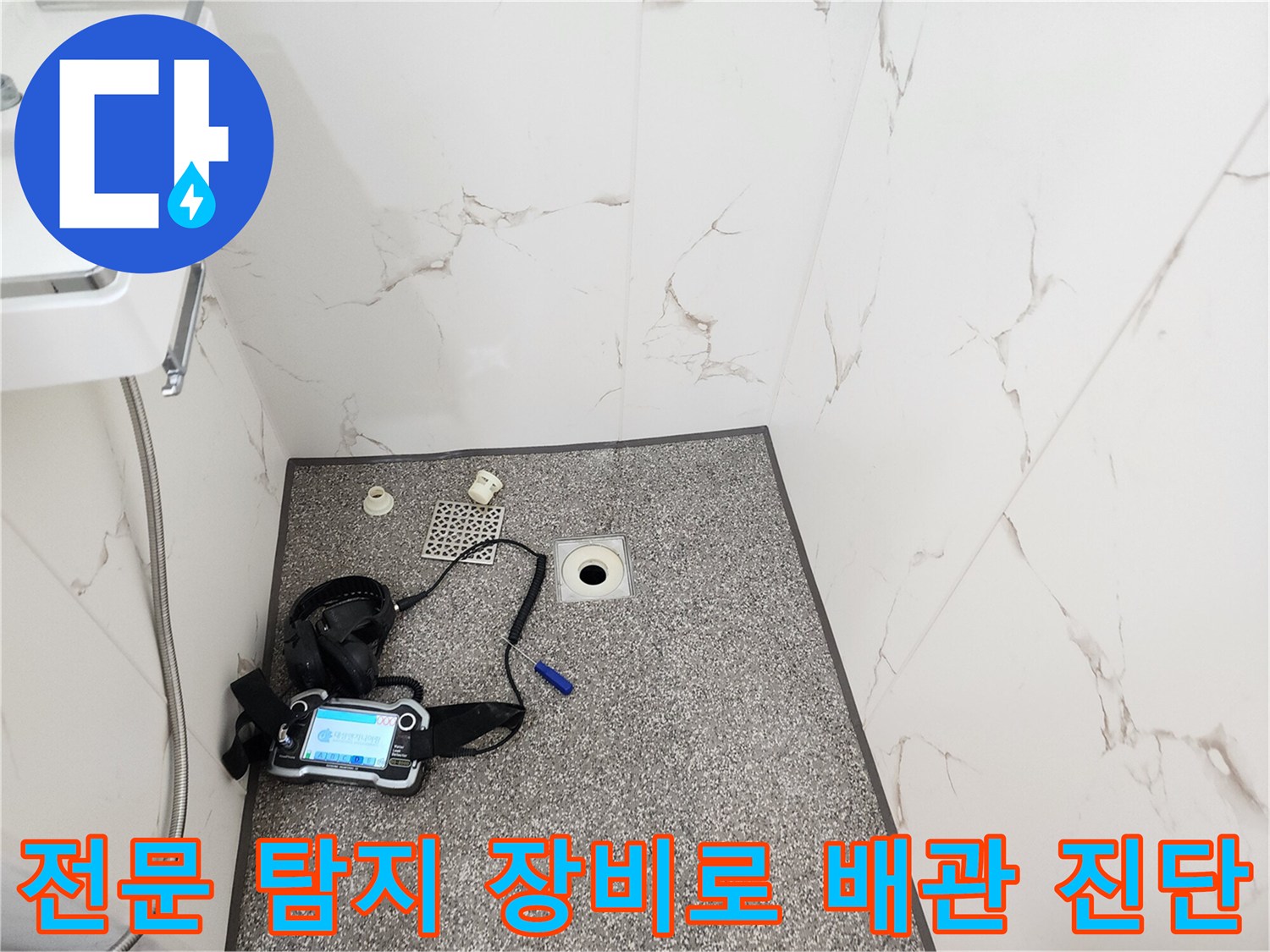화장실 바닥에 놓인 가스식 누수 탐지기와 검사용 부품들