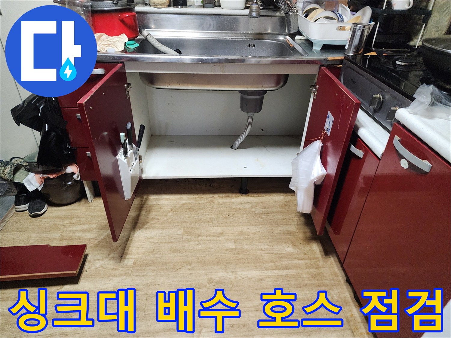 싱크대 하단 배수 호스의 연결 상태와 바닥 물 고임 여부를 촬영한 사진입니다.
