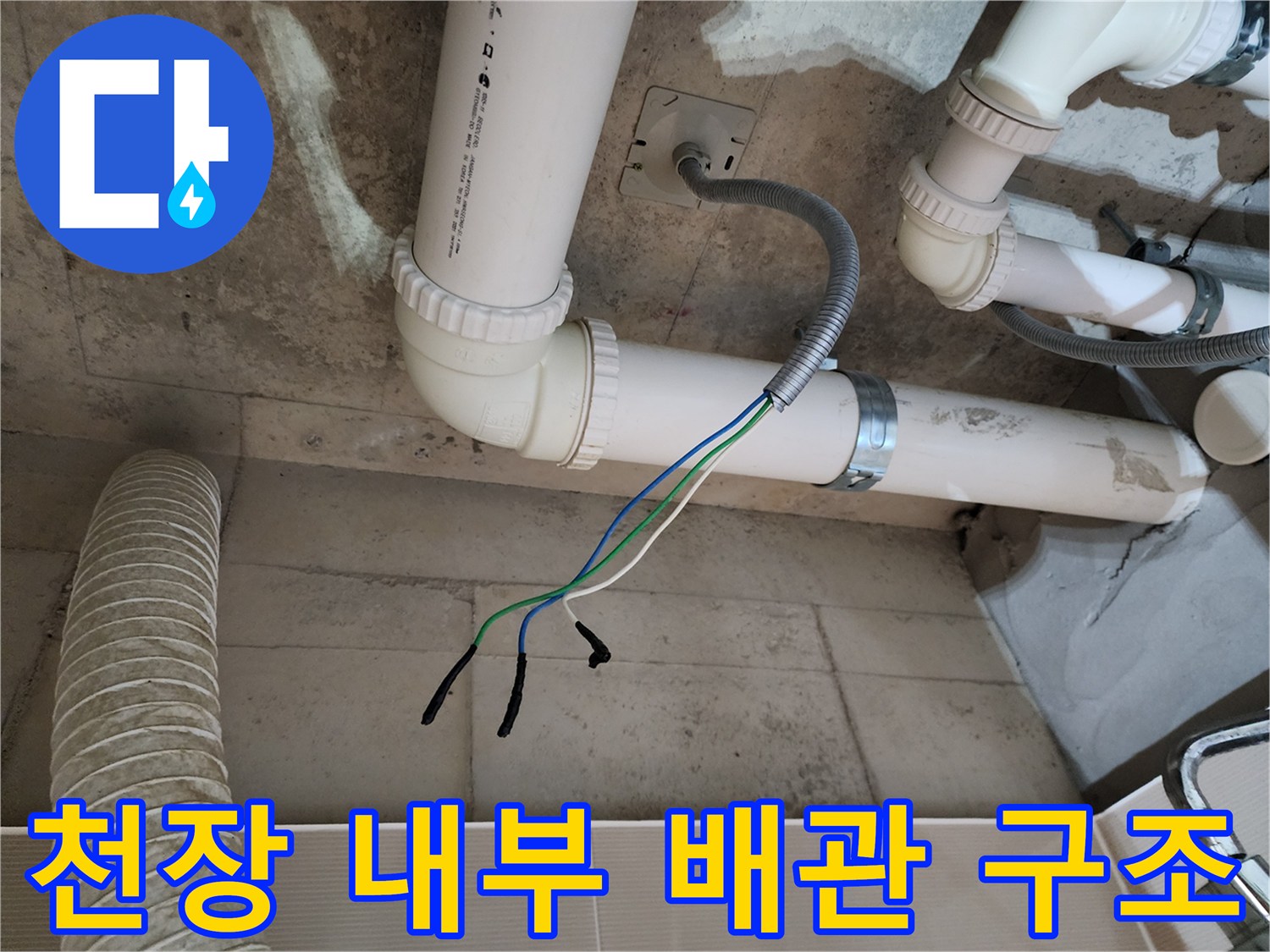 하얀색 PVC 배관과 전기 전선이 노출된 천장 내부 모습입니다.
