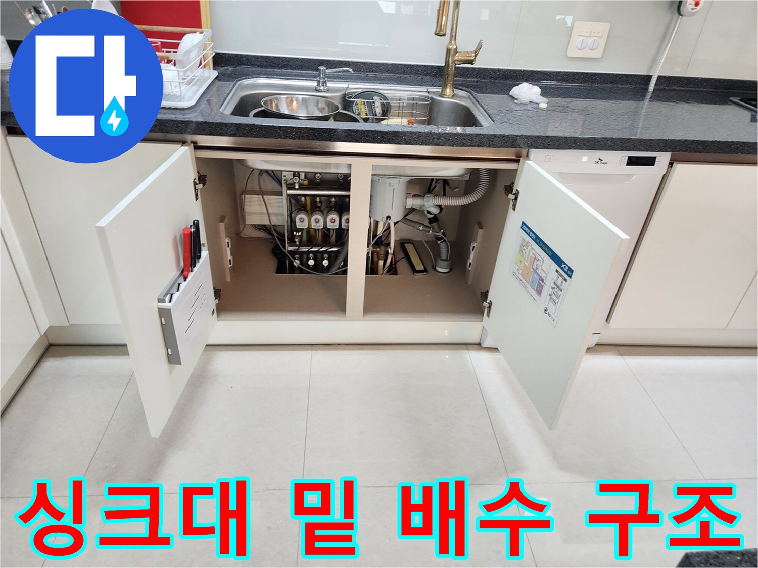 싱크대 하부장 내부에 노출된 배수관과 연결 호스 상세 사진