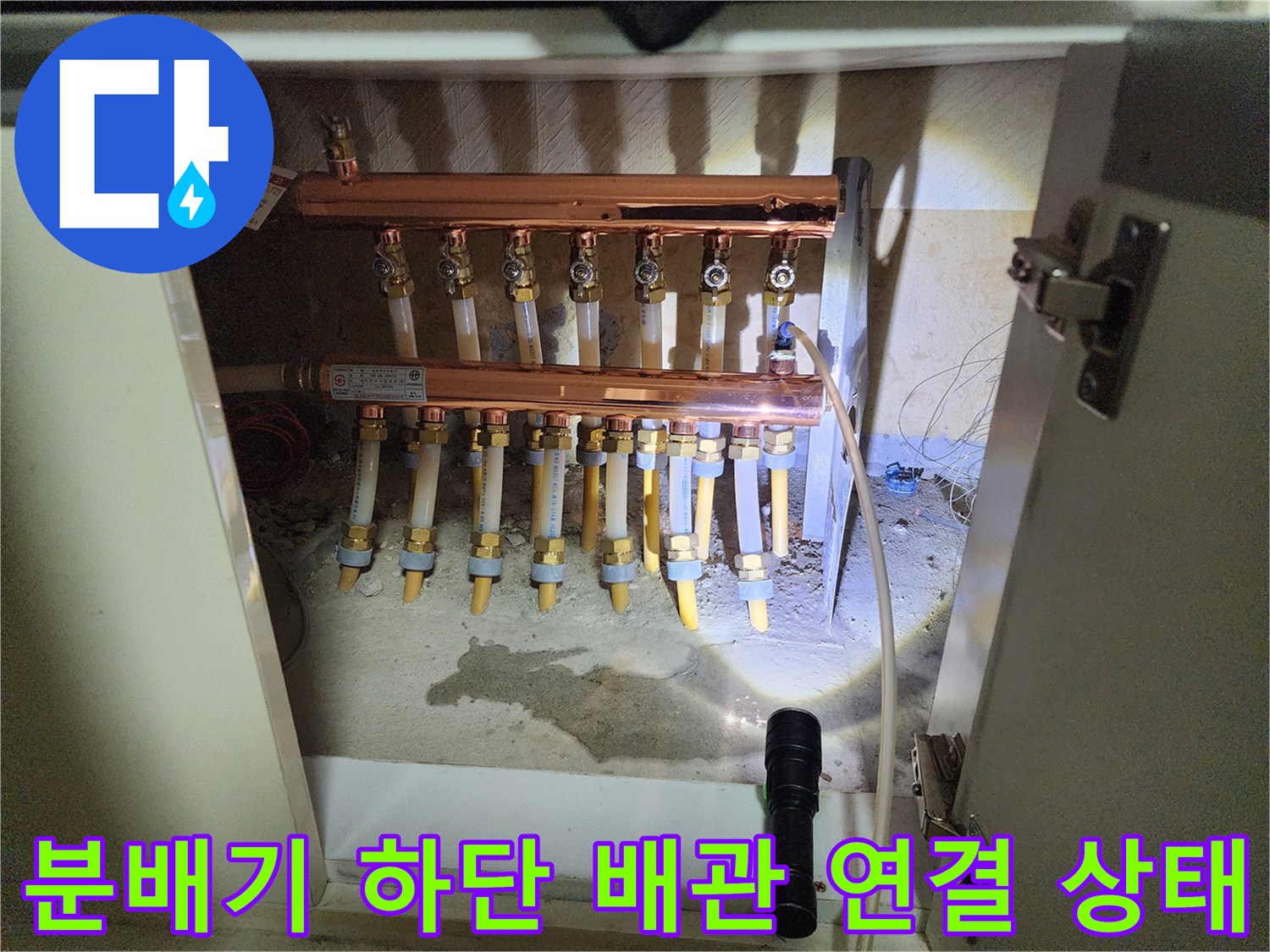 싱크대 아래 분배기와 연결된 난방 배관들의 모습