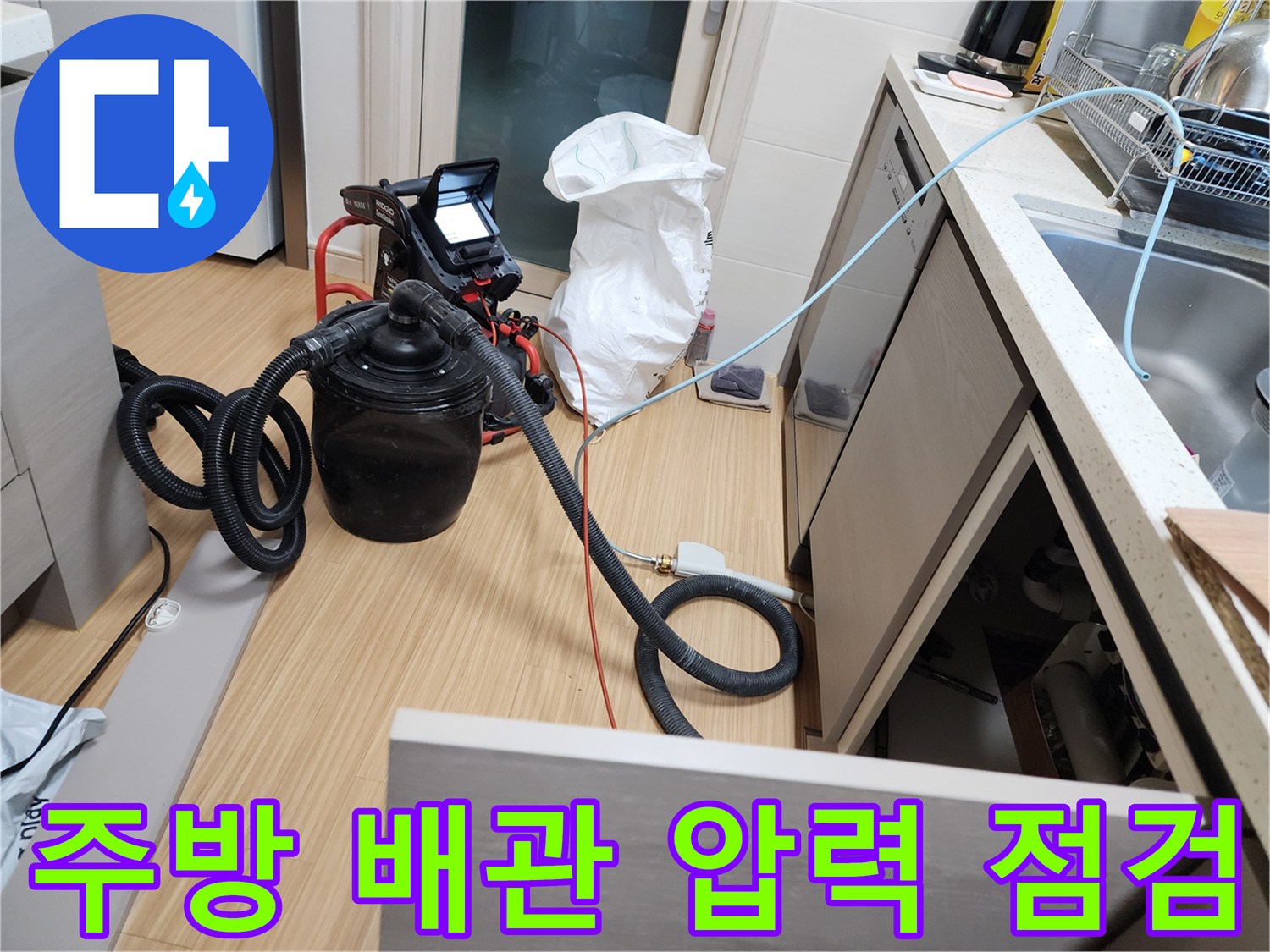 싱크대 하부 공간에서 진행 중인 배관 공압 테스트 장비 모습