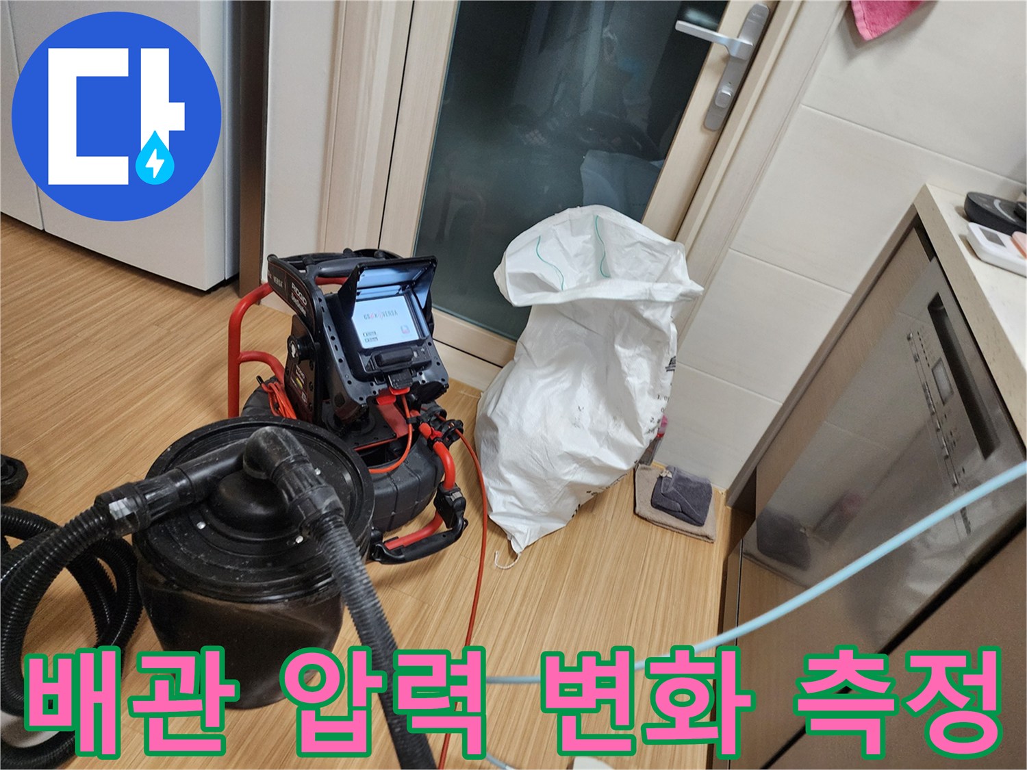 싱크대 하부 배관에 연결된 공압 테스트 장비와 디지털 게이지의 모습