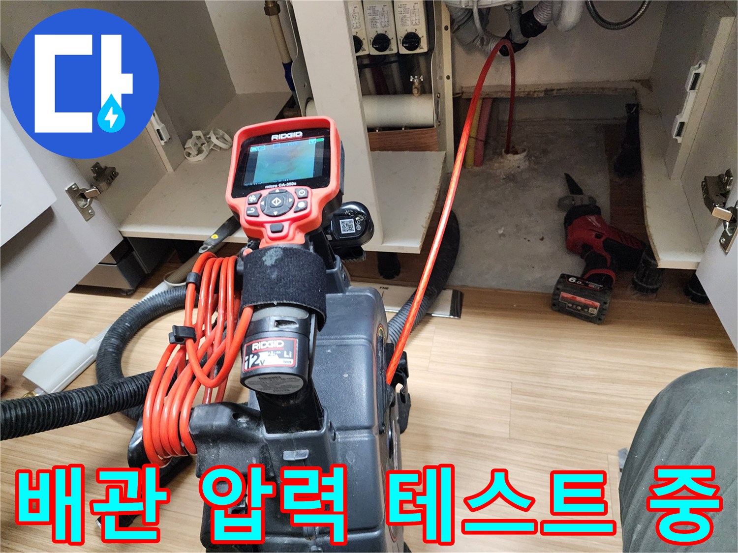 싱크대 하부장 내부에서 진행하는 배관 공압 테스트 모습