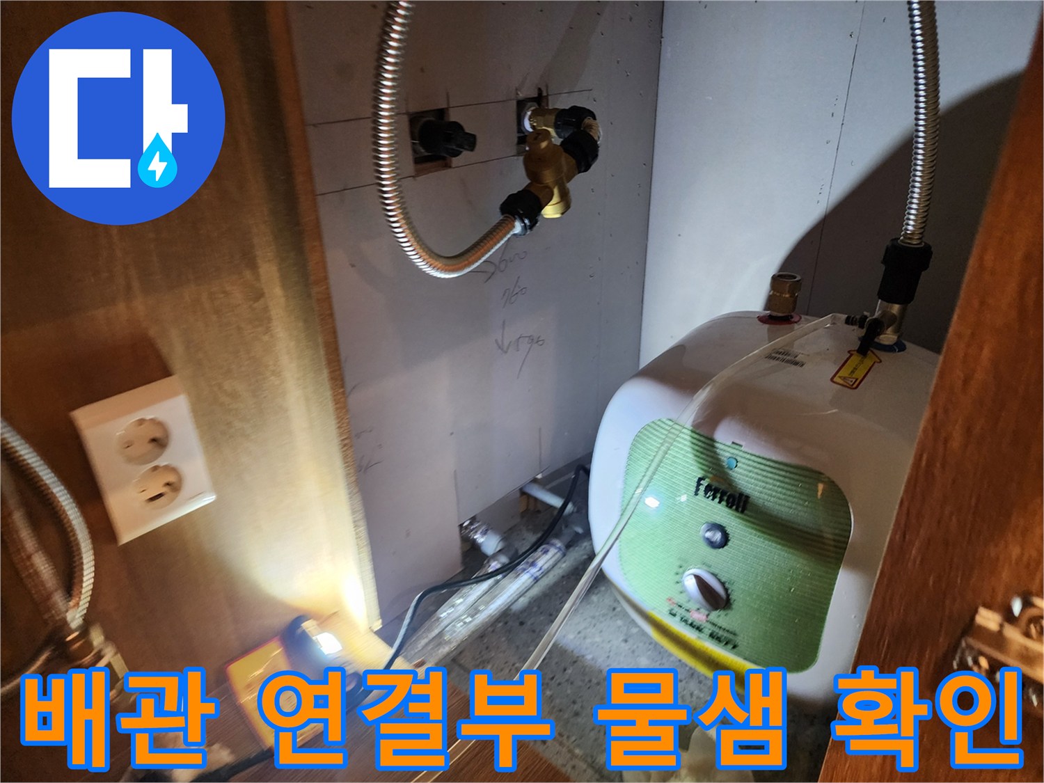 주방 하부장의 전기 온수기와 수도 배관 연결 상태