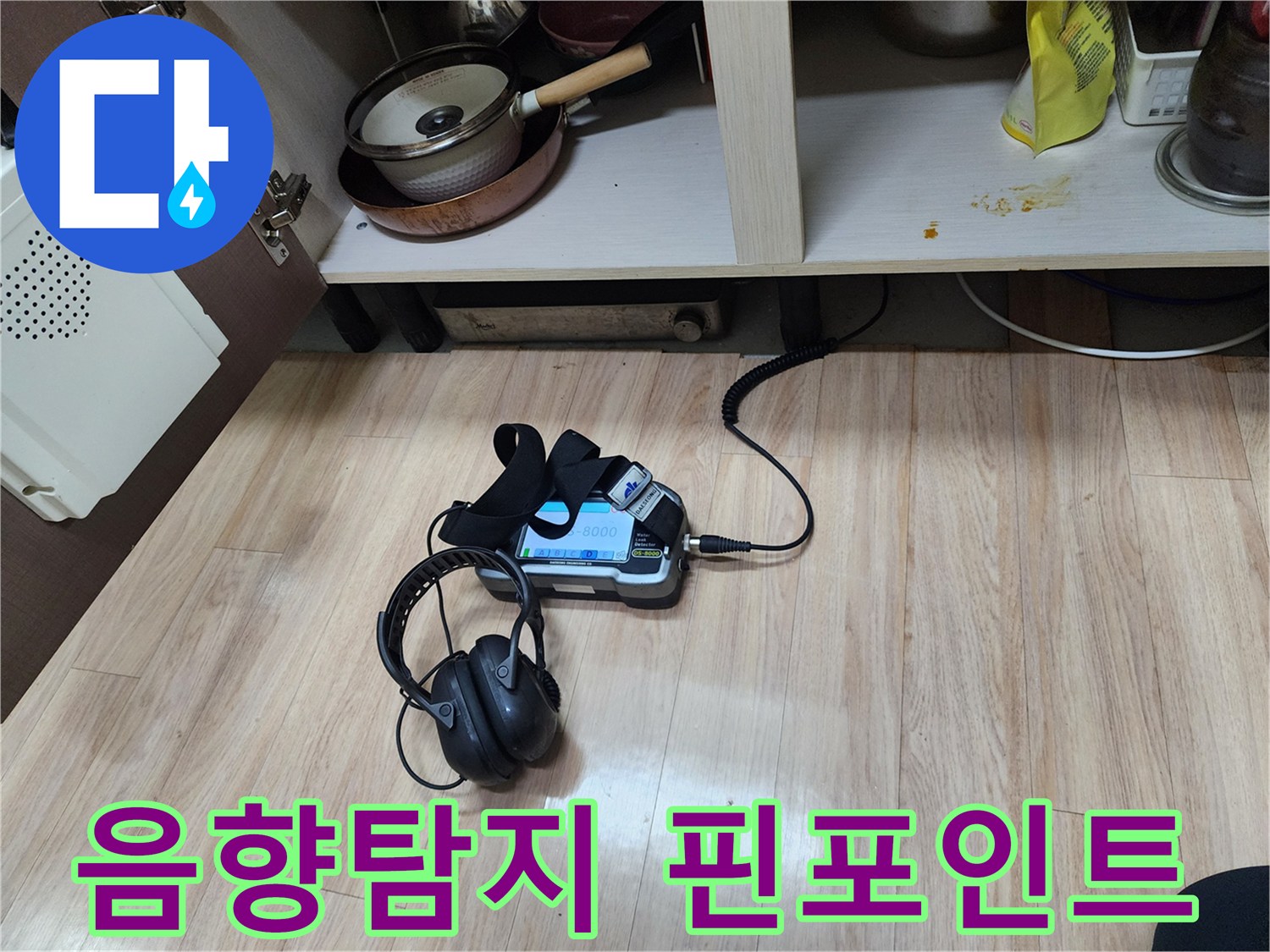누수 지점을 핀포인트로 찾아내기 위해-첨단 음향 탐지 장비와-헤드폰을 사용하여-정밀 검사를 수행하는 모습입니다.