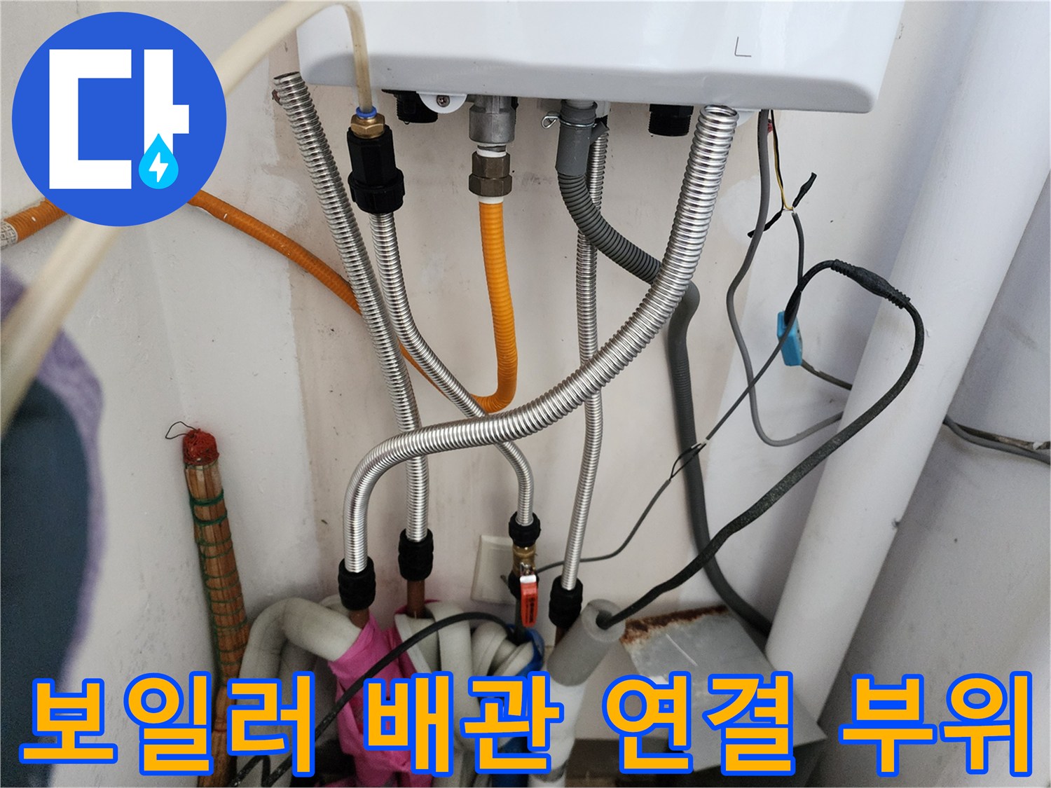 보일러 하부의 금속 주름관과 유연한 호스들이 연결된 모습