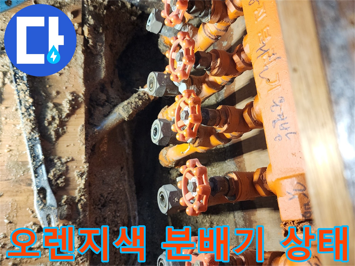 오렌지색 보온재로 감싸진 난방 분배기 밸브 부위 사진입니다.
