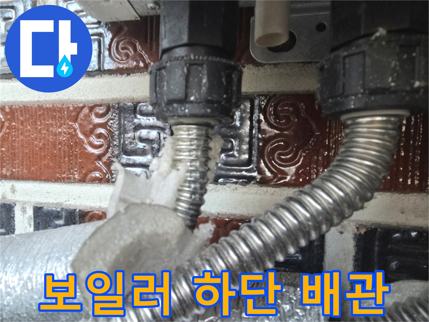 보일러 하단-금속 주름관과 검은색 연결 부품 근접