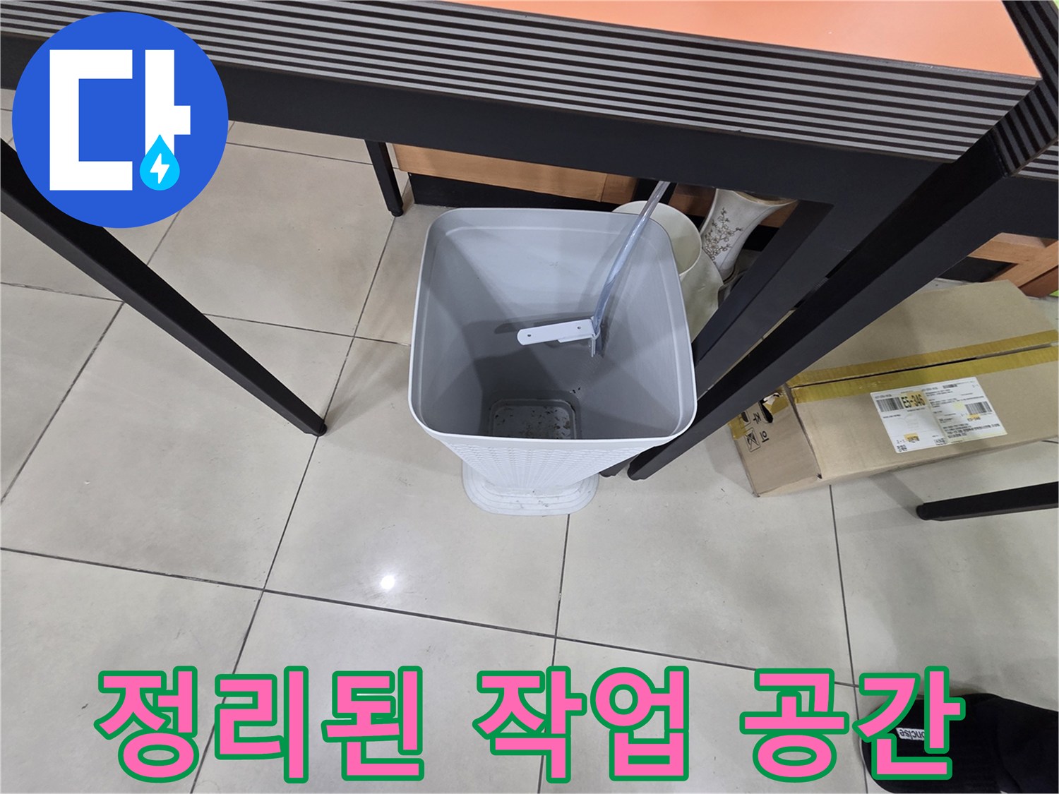 책상 아래 놓인 하얀 양동이와 주변 정리 상태