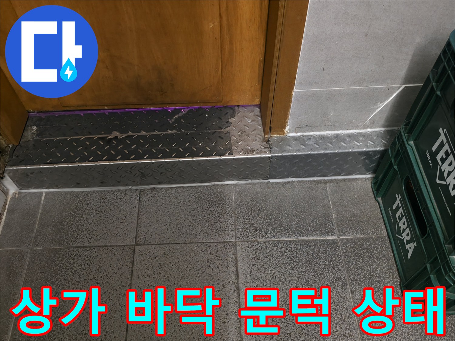 상가 매장 내부의 타일 바닥과 금속 문턱 경계 부분 사진