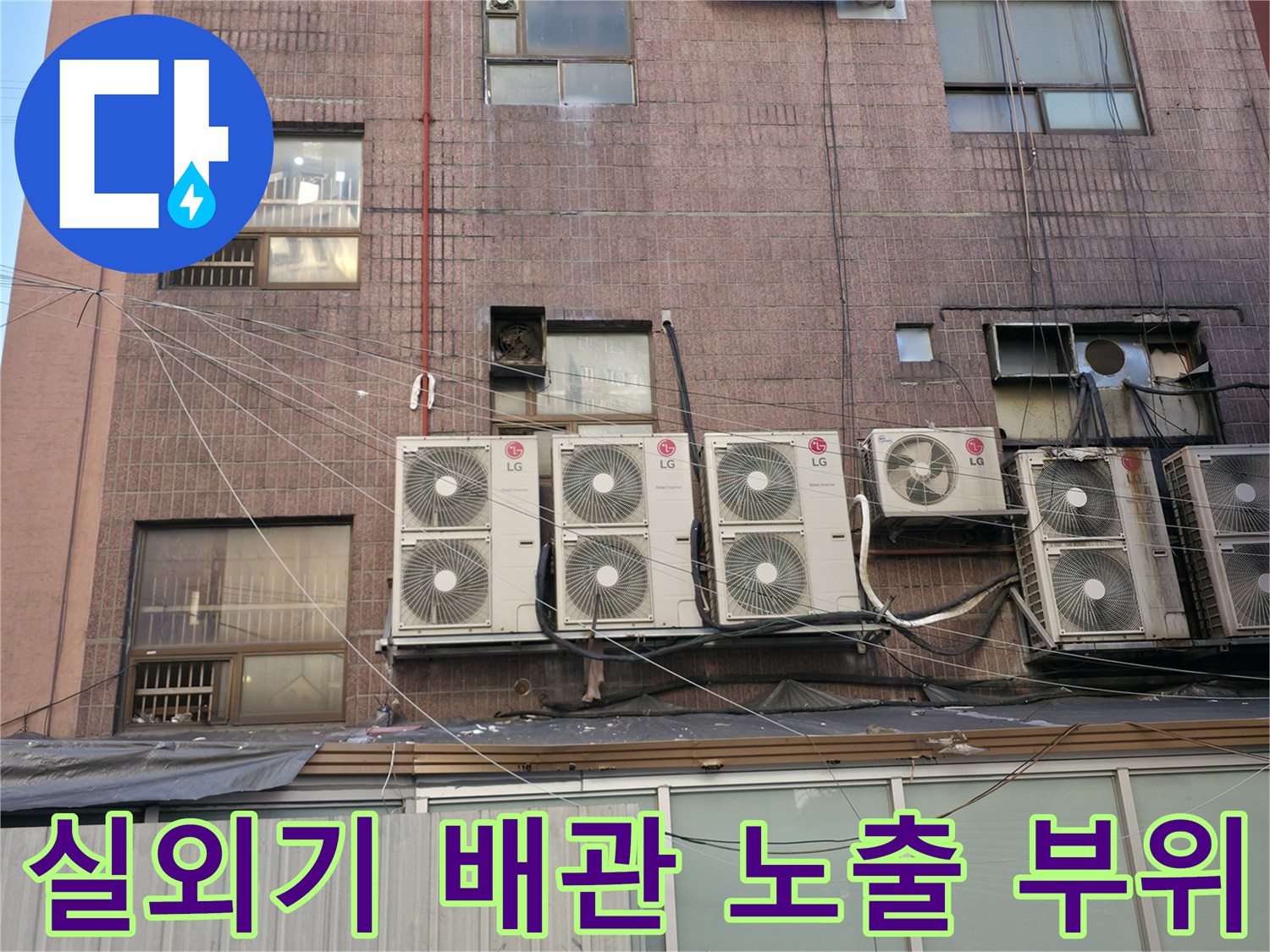 상가 외벽에 설치된 에어컨 실외기와 연결된 배관들