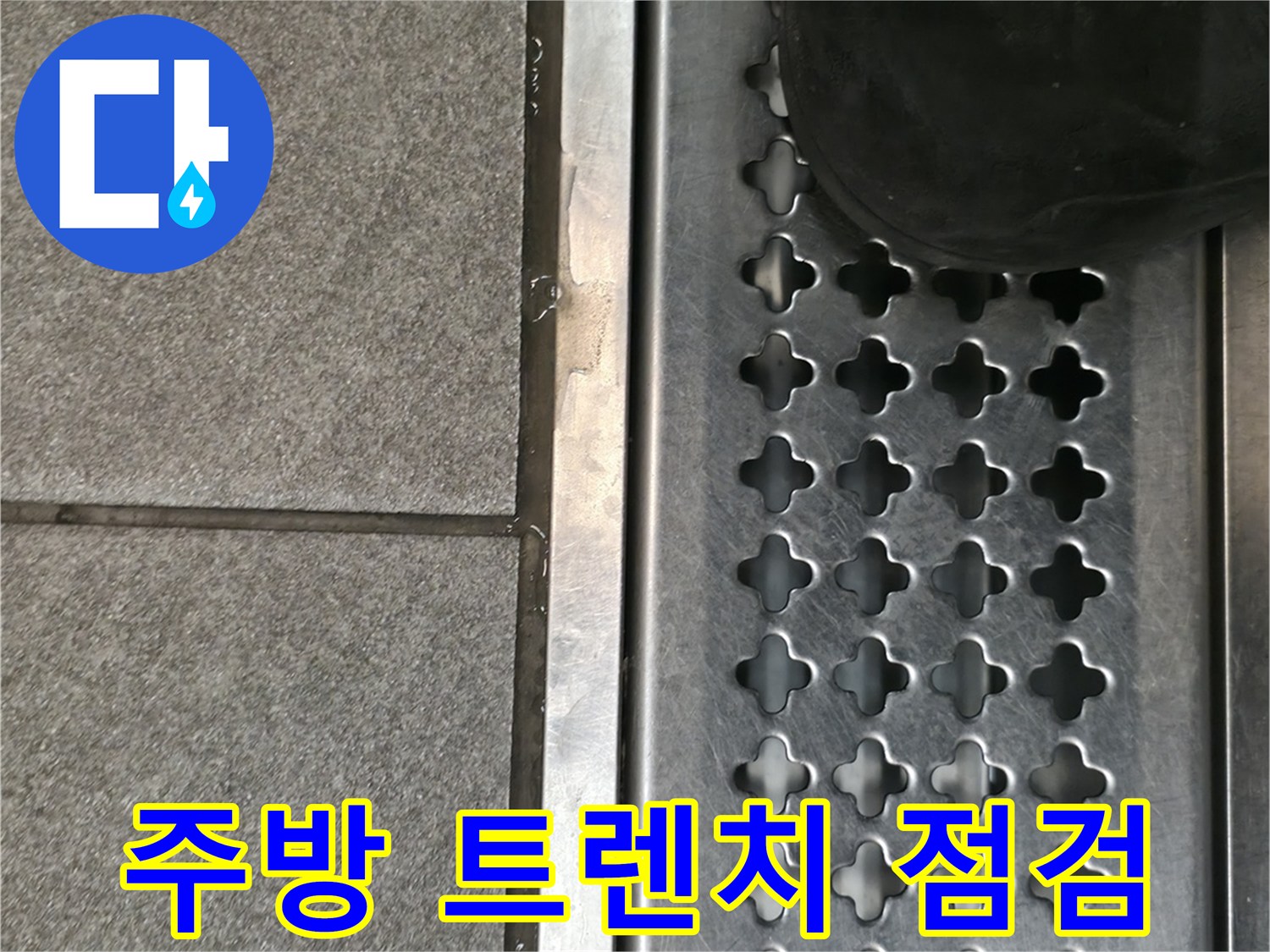 상가 주방의 스테인리스 배수 트렌치와 타일 바닥 상태