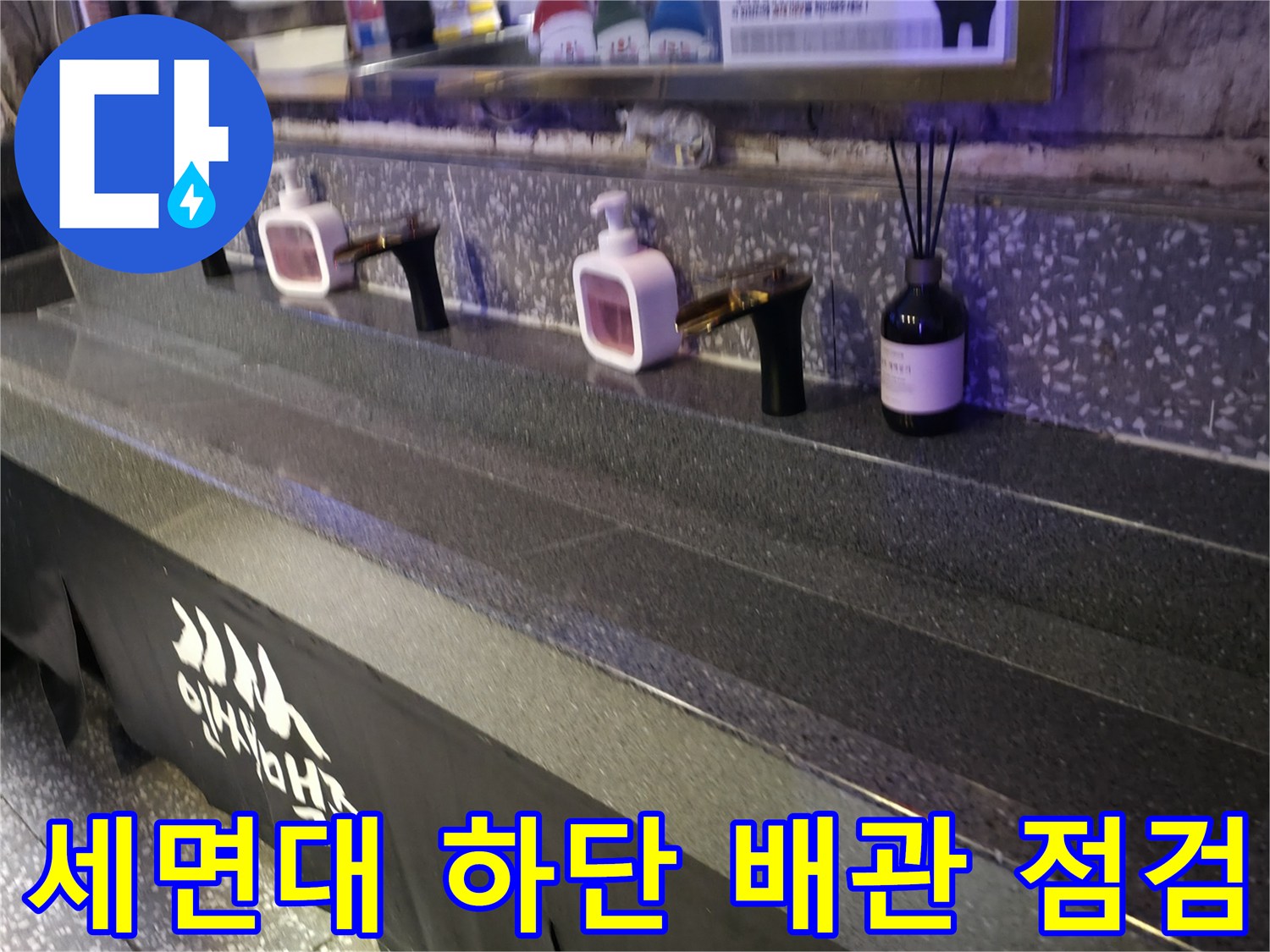 상가 화장실 세면대와 벽면 수전의 근접 촬영 이미지입니다.