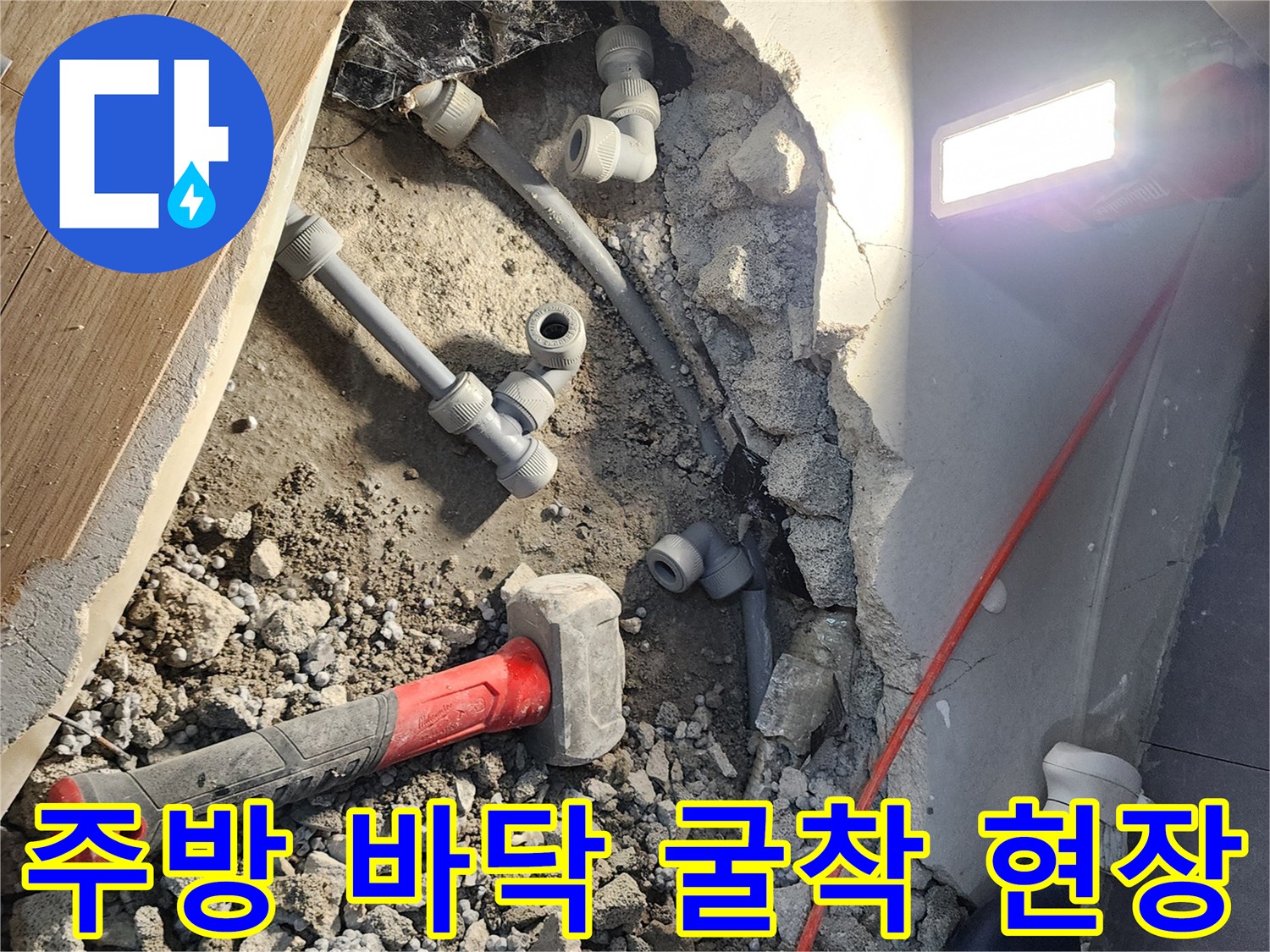 싱크대 아래 콘크리트 바닥을 파내어 드러난 회색 배관 연결 부위