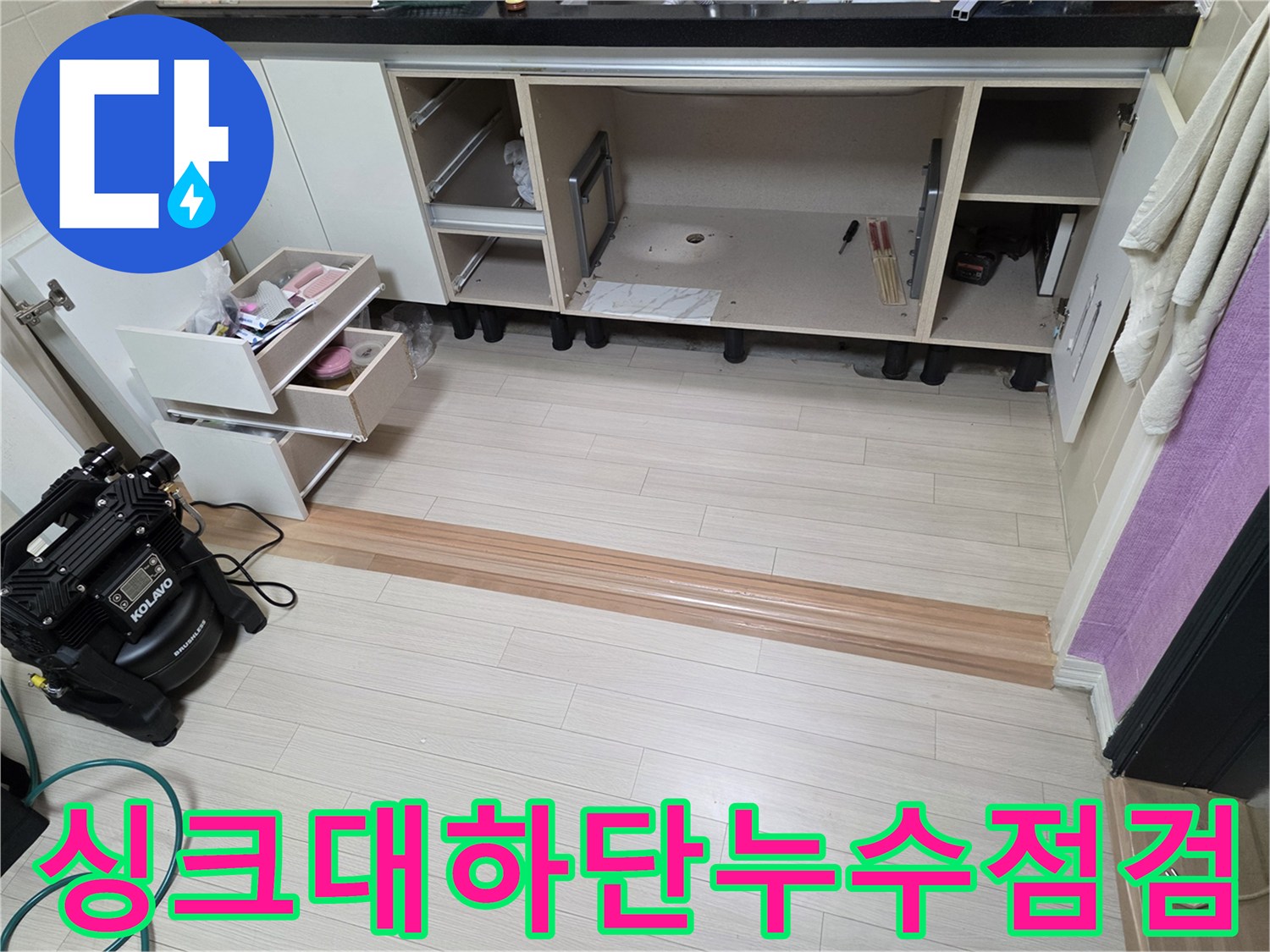싱크대 하부장 내부를 비워두고 배관을 점검하는 모습