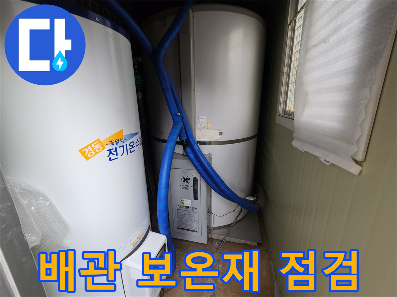 파란색 보온재로 마감된 온수 공급 배관과 전기 온수 탱크의 모습