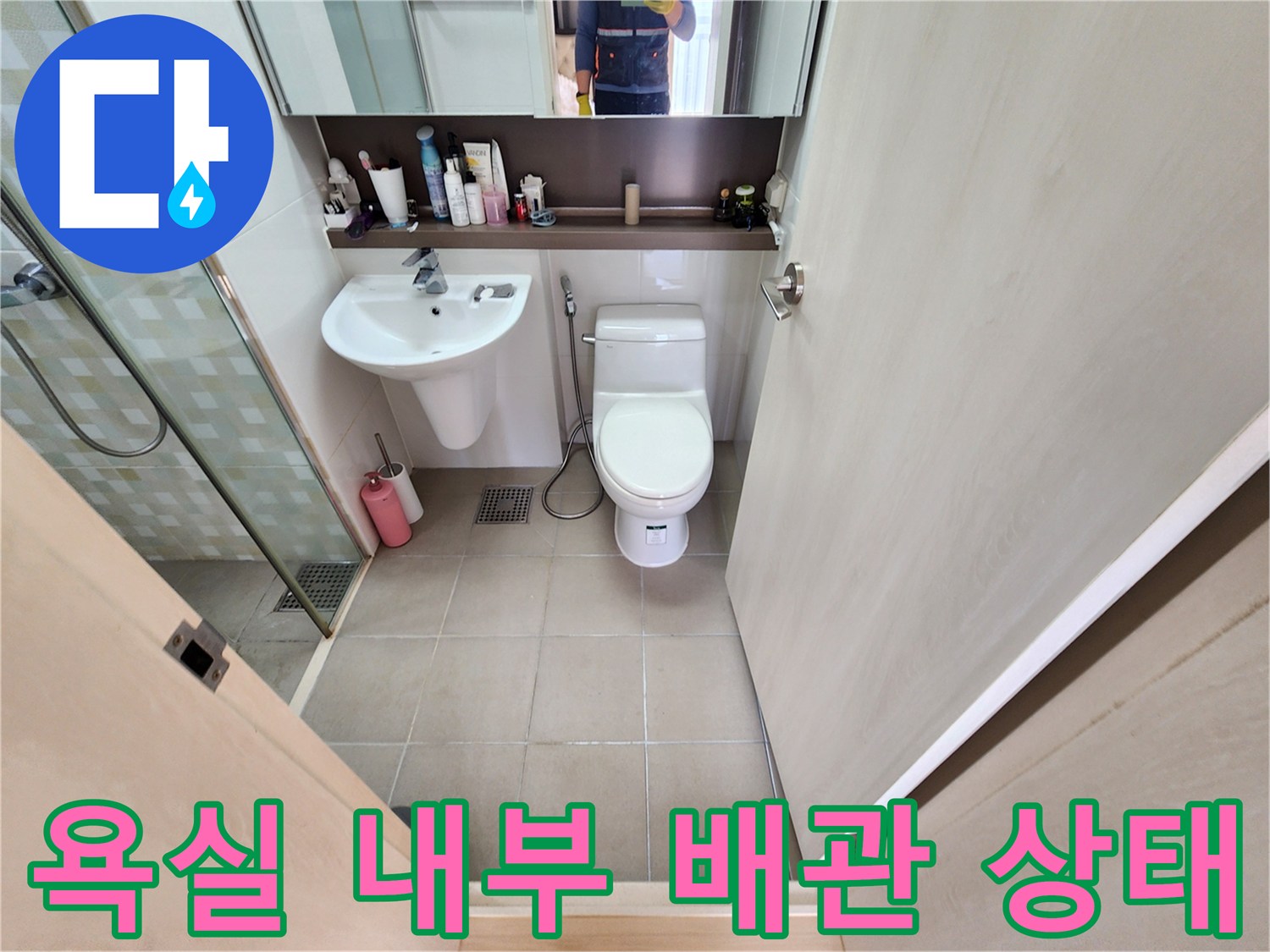 화장실의 변기와 세면대 주변을 촬영한 이미지입니다.