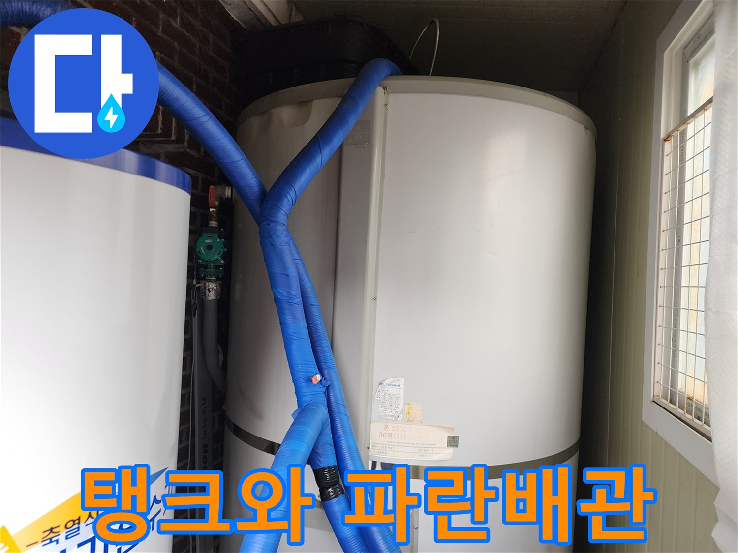 흰색 대형 탱크에 연결된 파란색 단열 배관의 모습입니다.