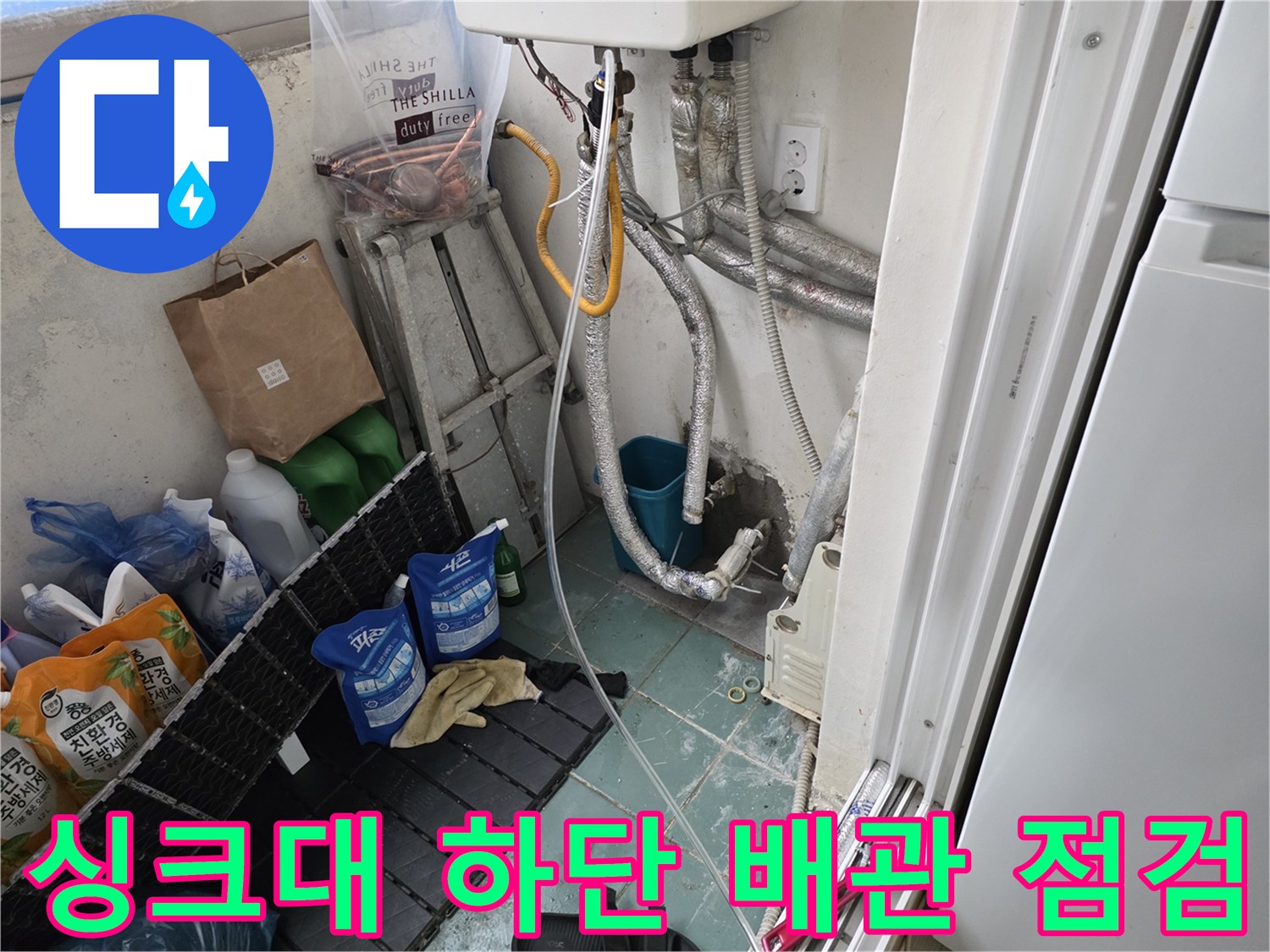 복잡하게 연결된 은색 보온재 배관과 주변 물품들이 보이는 현장 사진입니다.