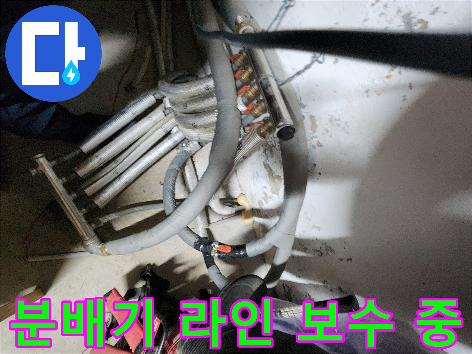 복잡하게 얽힌 분배기 배관과 전문 수리 장비의 모습