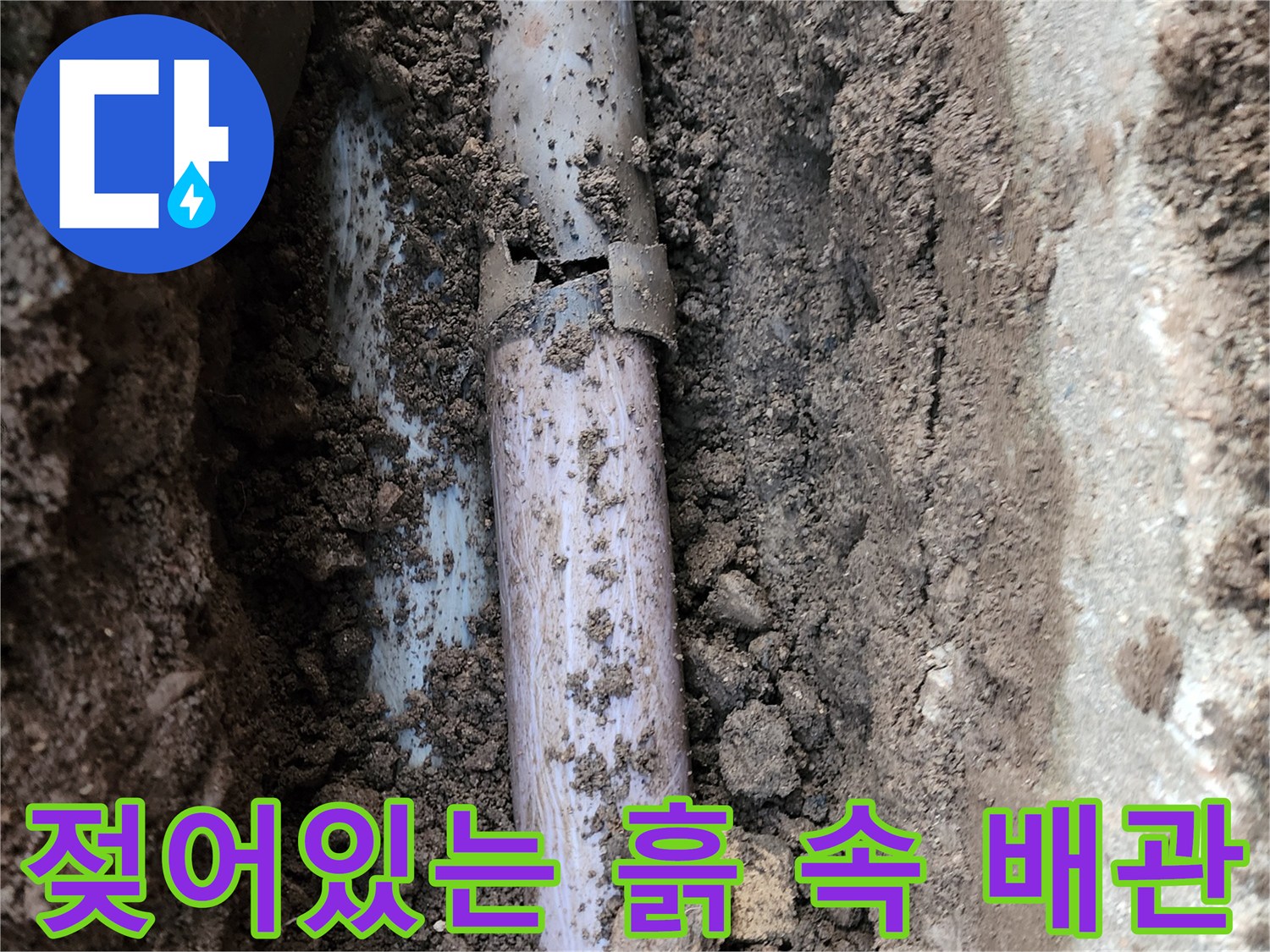 습기를 머금은-흙 속에 드러난 노후된 배관의 모습
