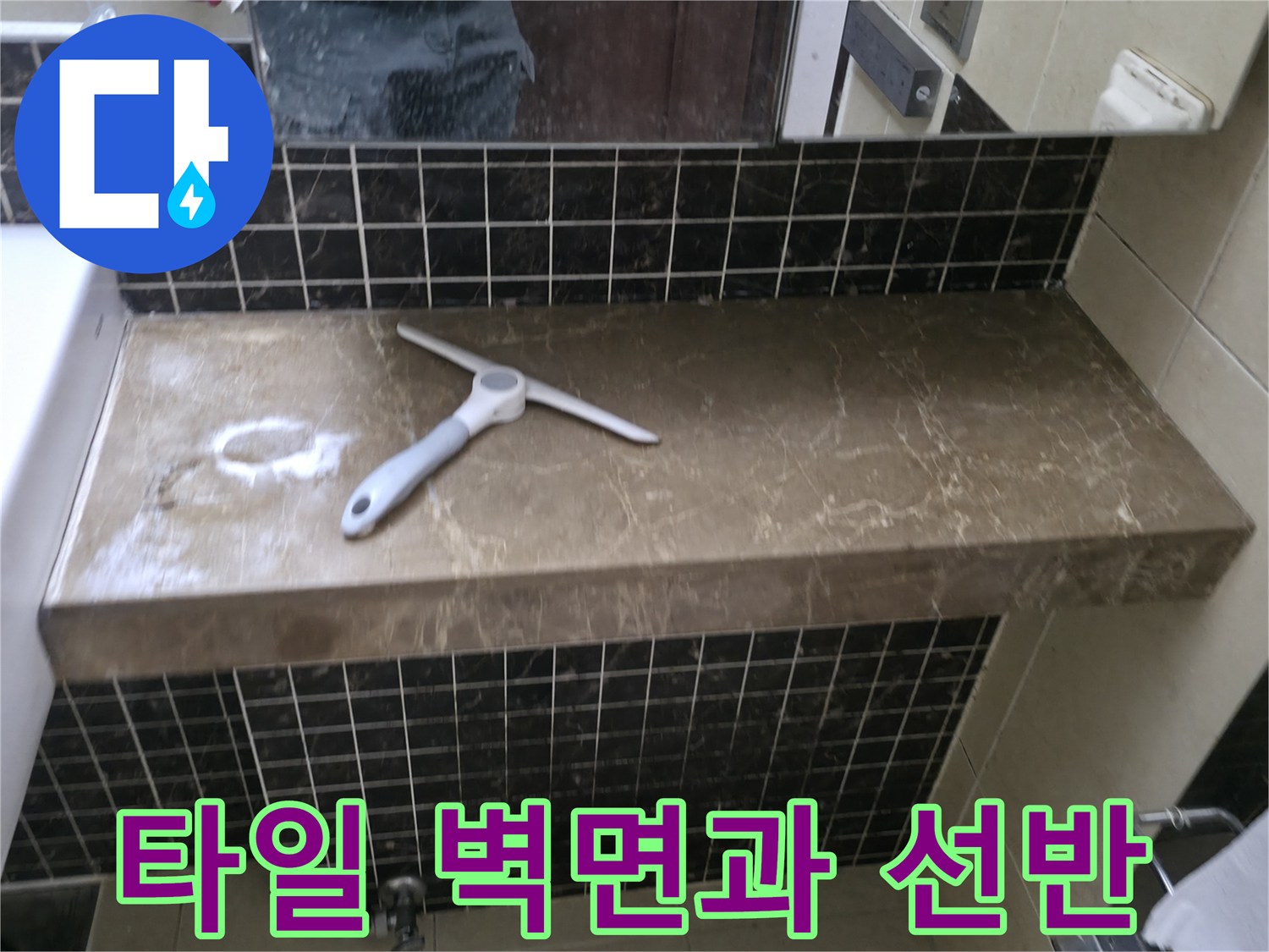 어두운 색상의 타일 벽면과 대리석 느낌의 선반