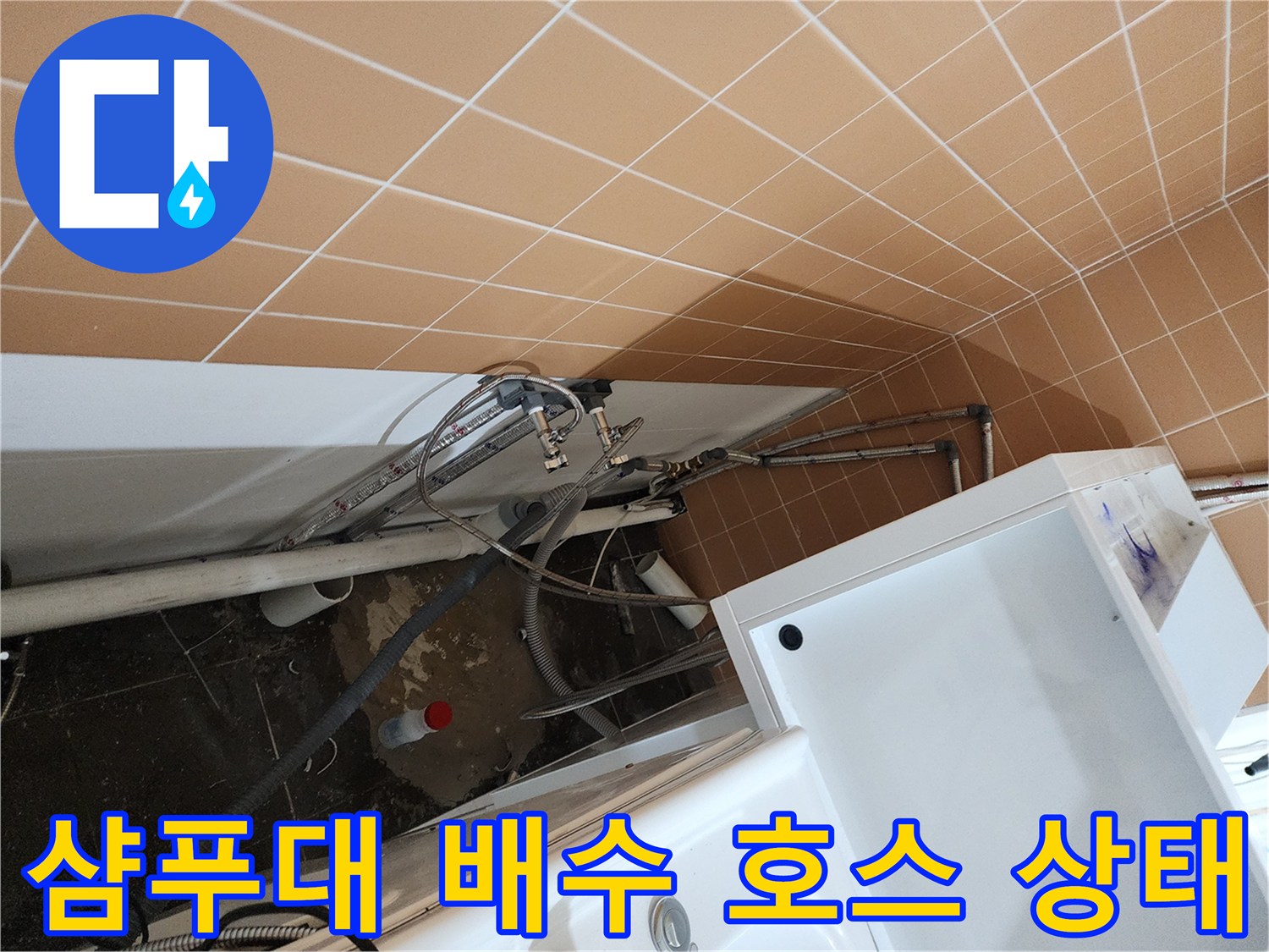 샴푸대 본체에서 내려오는 배수 호스와 벽면 배관의 연결 모습입니다.