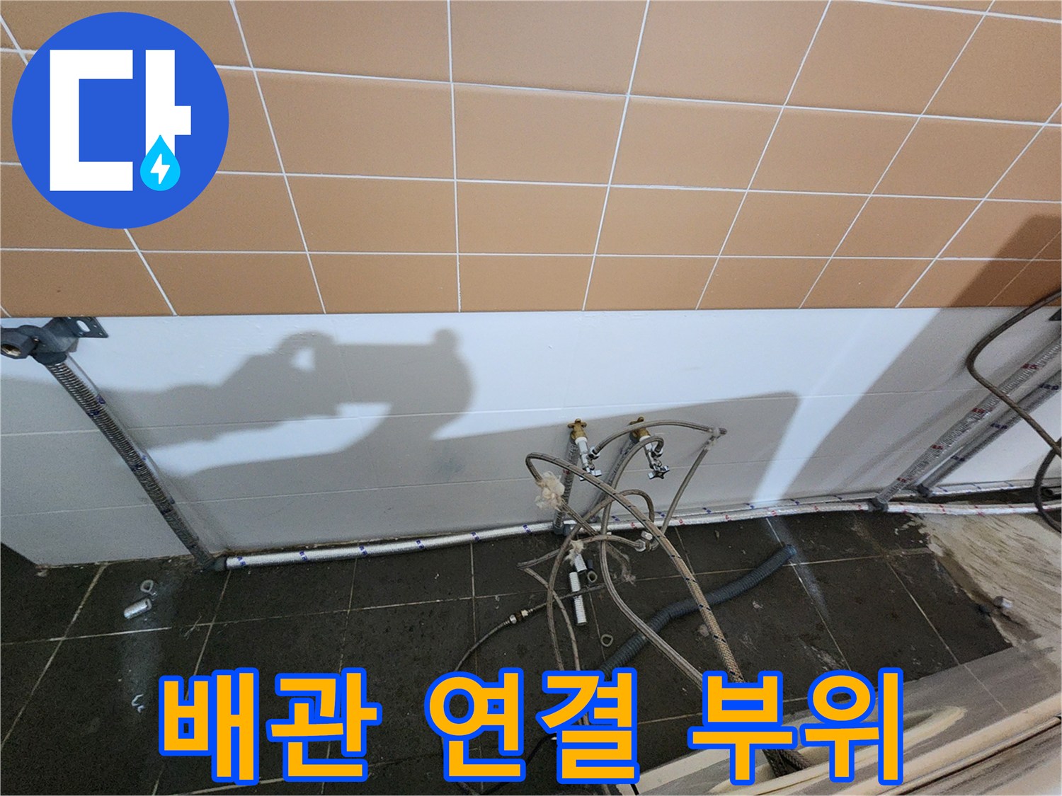 샴푸대 하단에 위치한 복잡한 배관들의 연결 상태를 근접 촬영하였습니다.