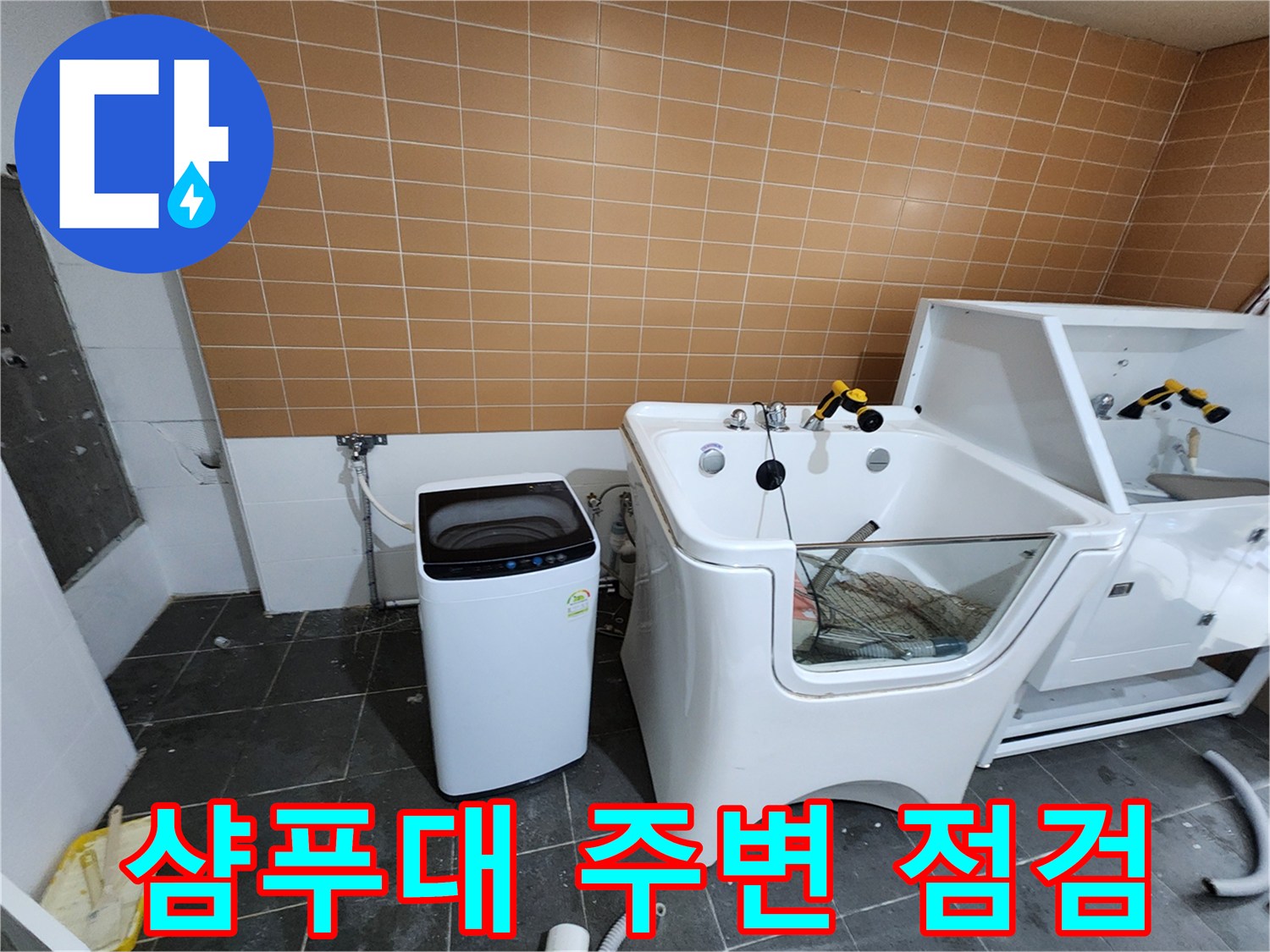 샴푸대와 세탁기 사이의 배관 연결 부위를 살피는 모습입니다.