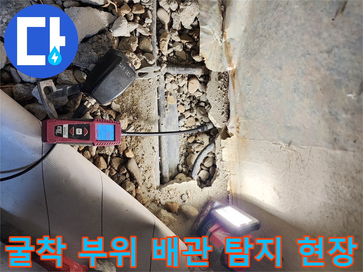 파헤쳐진 바닥 틈새-배관의 누수 여부를 판단하기 위해 측정 중입니다.