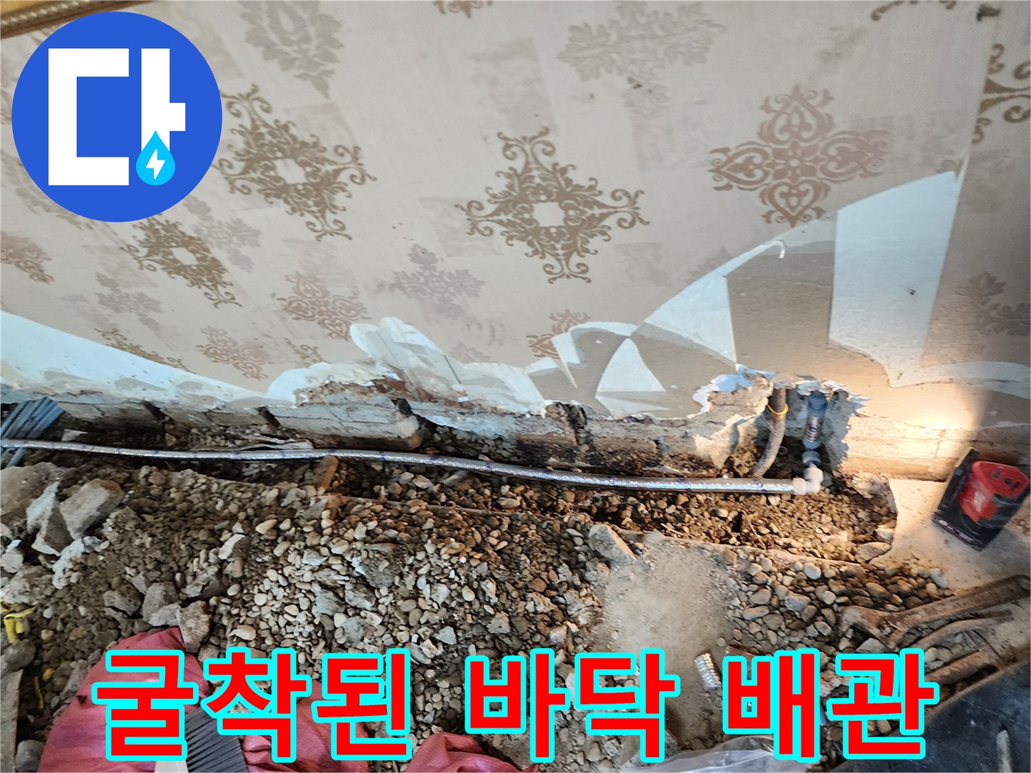 벽면 아래 흙을 파낸-공사 중인 매립 배관 부위