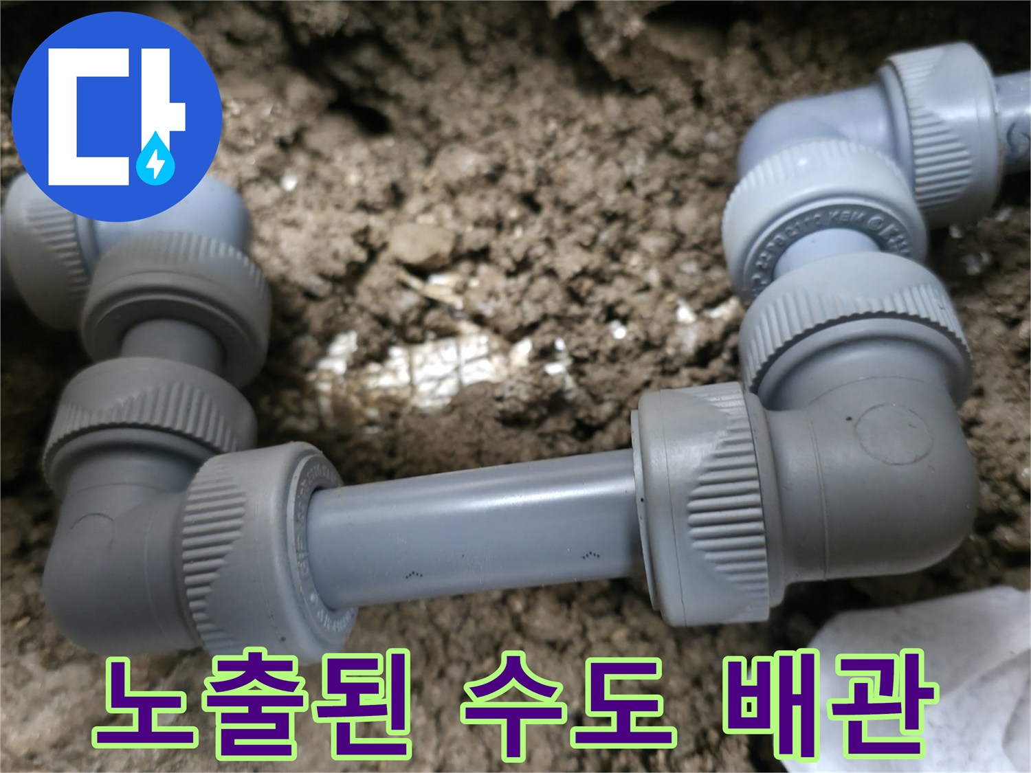 흙이 묻어 있는-외부 배관의 연결 부속과 분기 구간 사진입니다.
