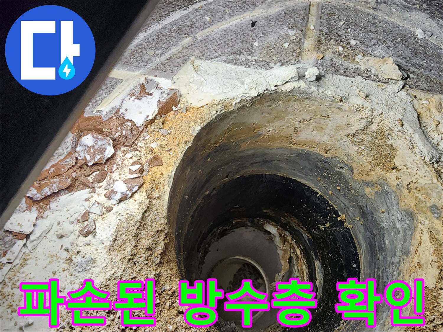 하수구 배관 주변의 젖은 모래와 깨진 마감재 부위