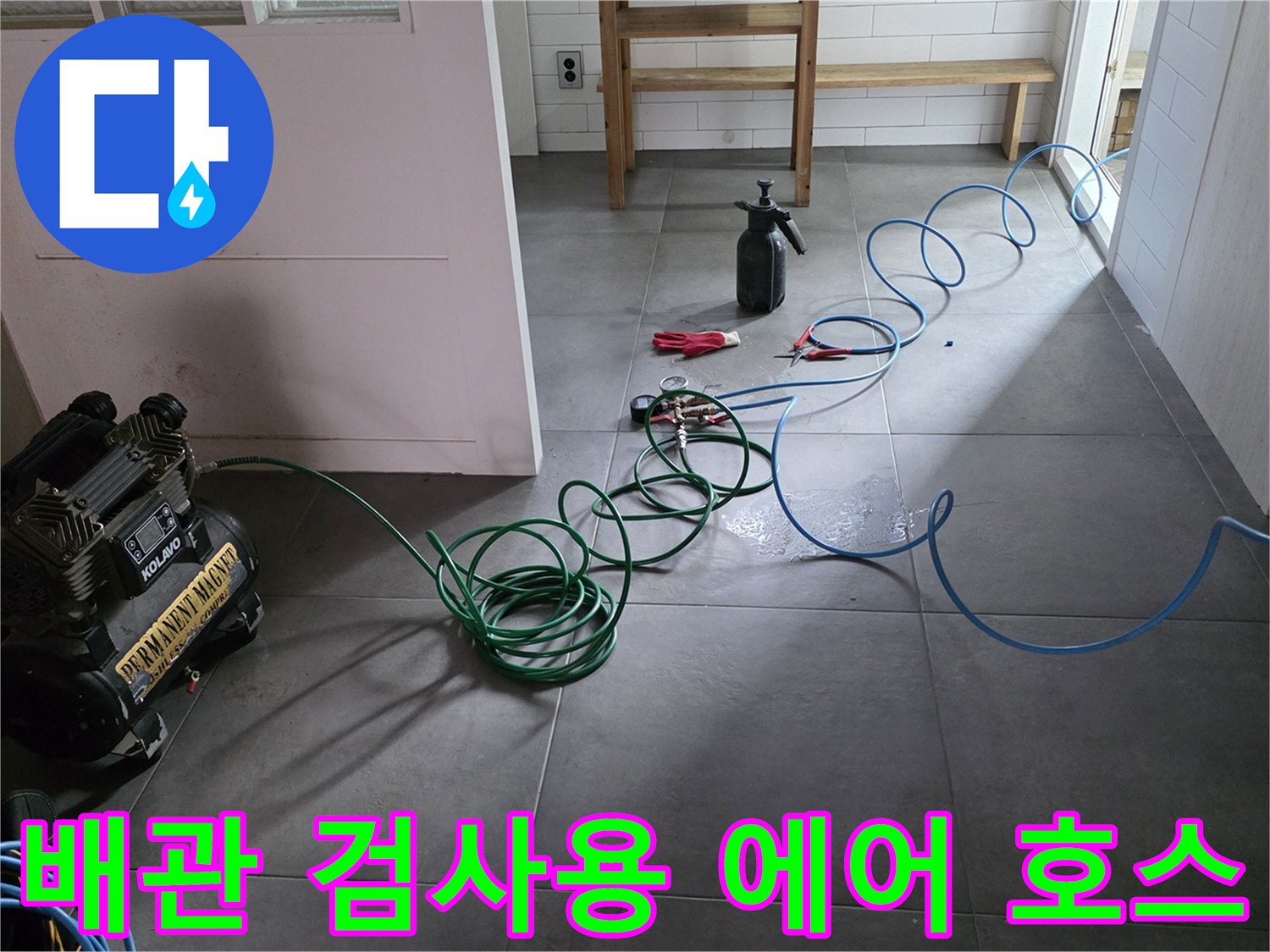 바닥에 연결된 초록색과 파란색의 누수 탐지용 공기 압축 호스